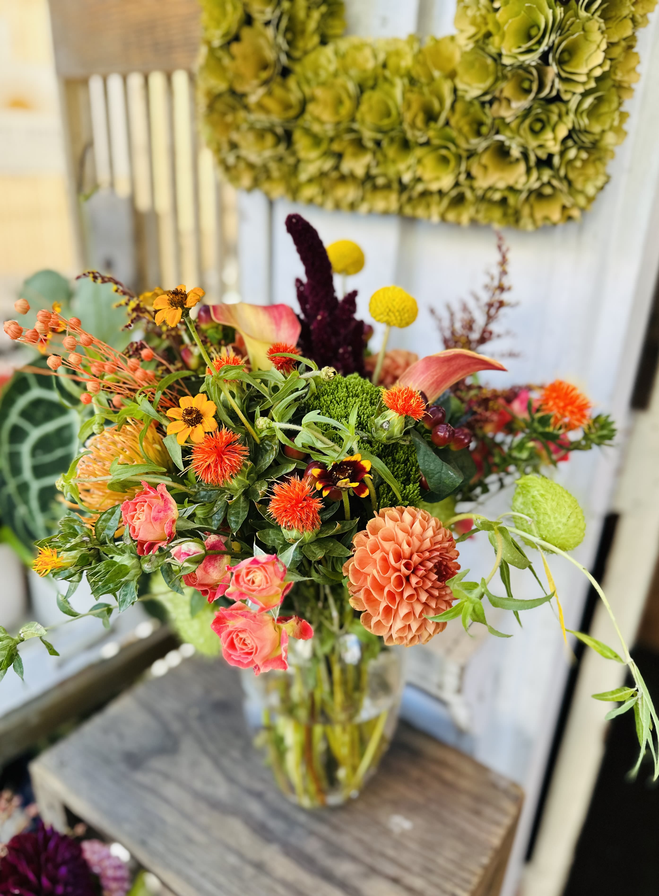 Mixed bouquet in a clear glass vase with pink, orange, and yellow blooms