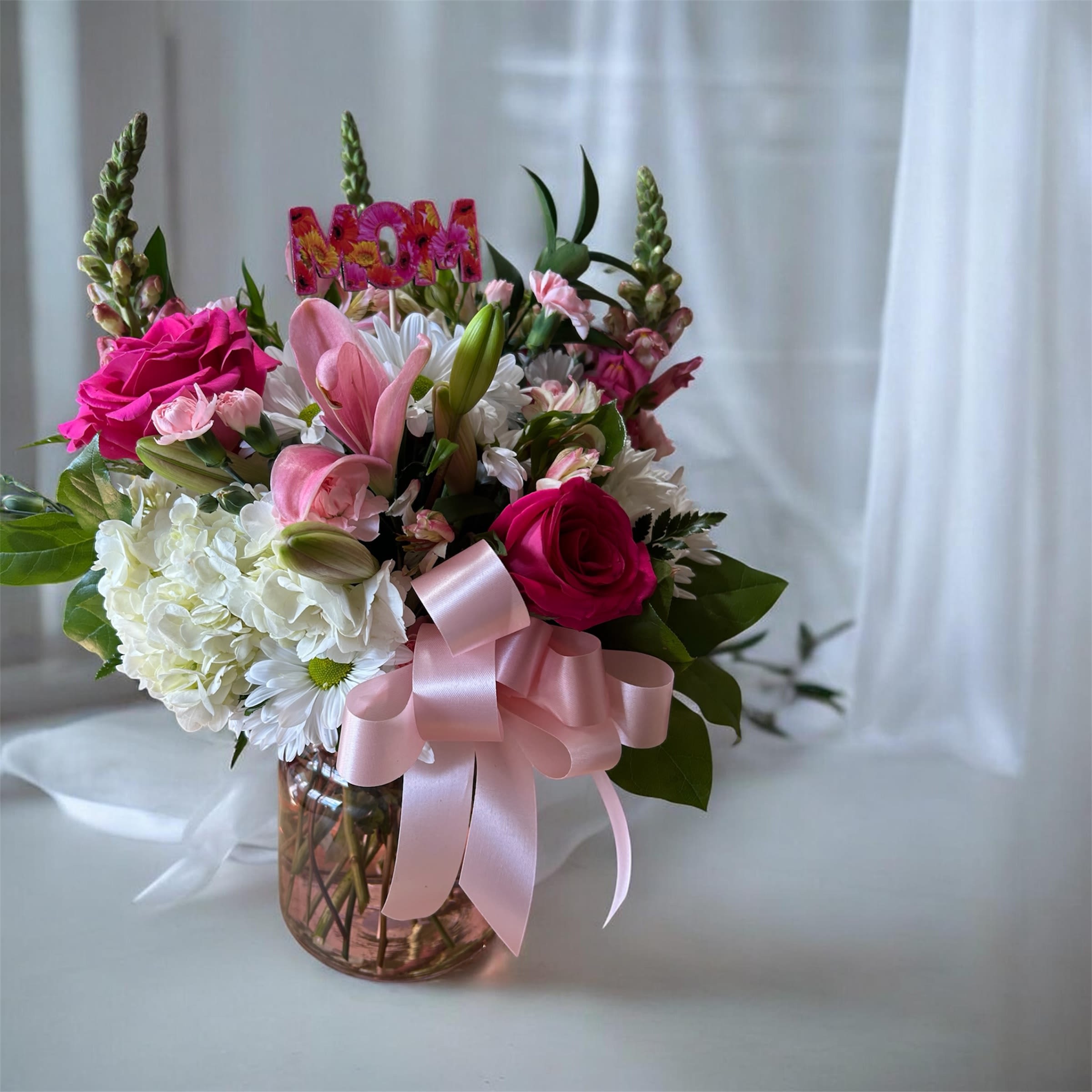 Pink Crystal Bouquet - Beautiful crystal pink vase with different pink flowers, like snapdragons, pink mini carnations, roses and a lily.  The bouquet also includes a white hydrangea with white daisies.