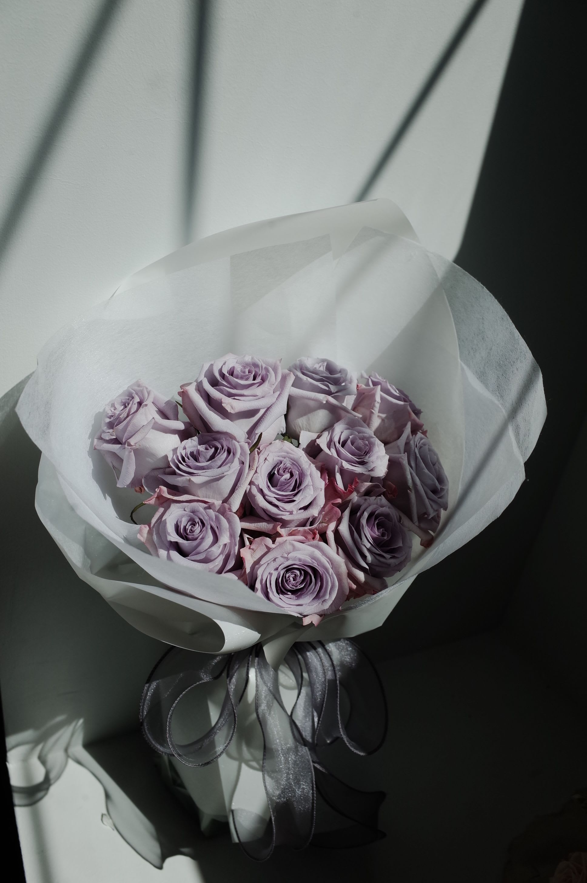 Moonlit Lavender Bouquet - A dreamy arrangement of premium lavender roses, each bloom opening in soft, velvety layers of purple. Their gentle hue brings a sense of calm, romance, and quiet luxury. Wrapped in complementary tones for a refined finish, this bouquet is perfect for anniversaries, heartfelt gifts, or anyone who loves soft, elegant colors.