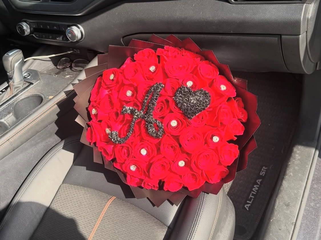 Classy Red - Perfect for an anniversary, romantic surprise, or special celebration where you want the recipient to feel adored, this arrangement reads as thoughtful and glamorous. Order with recipient name details in mind since the black glitter initial is a strong visual element; care is simple-keep stems in fresh water and out of direct heat to preserve bloom life.