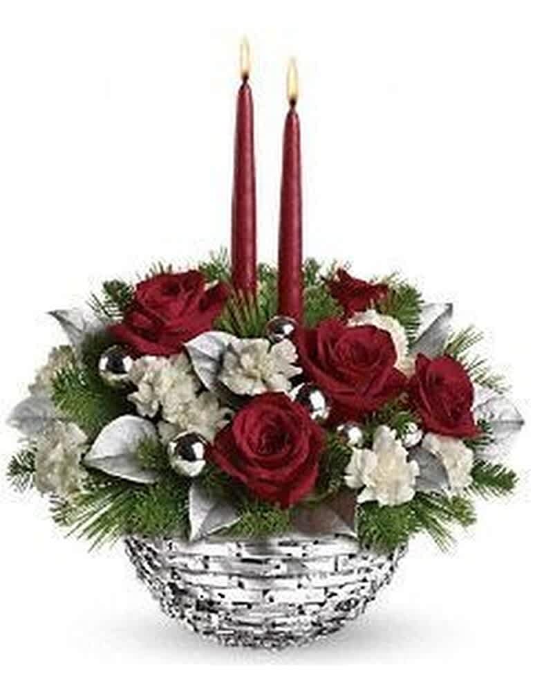 Red and white floral centerpiece with evergreens, silver accents, and two tall red candles in a white basket