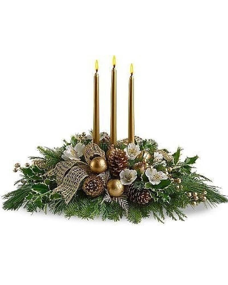 Long evergreen centerpiece with white flowers, pinecones, and three tall gold taper candles.
