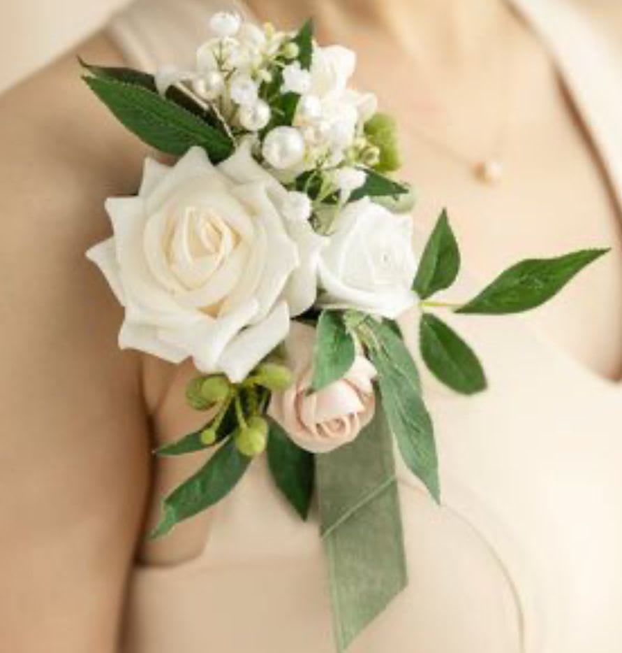 White rose boutonniere with small white blossoms and green leaves