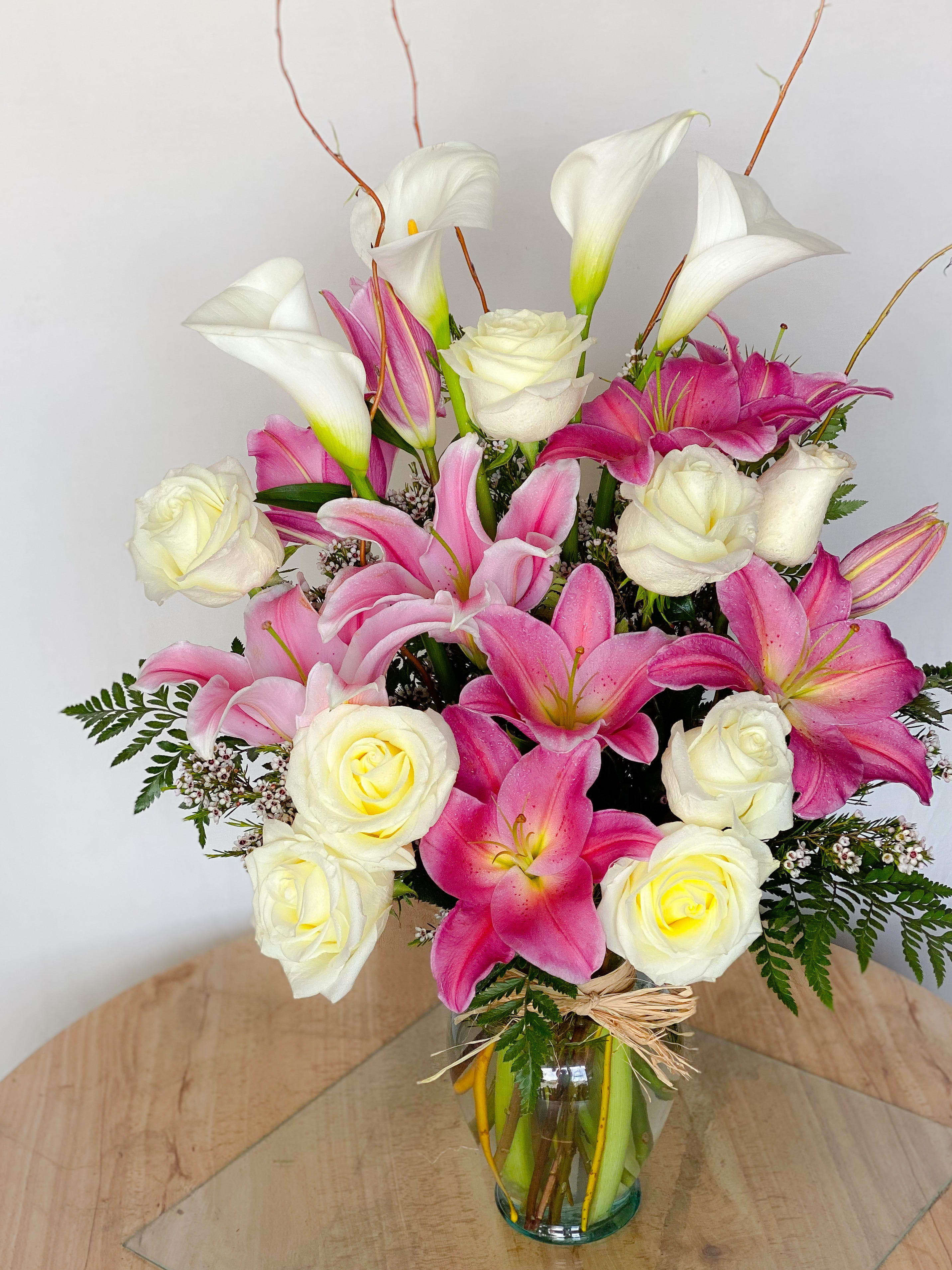 Pink lilies and white roses arranged in a glass vase