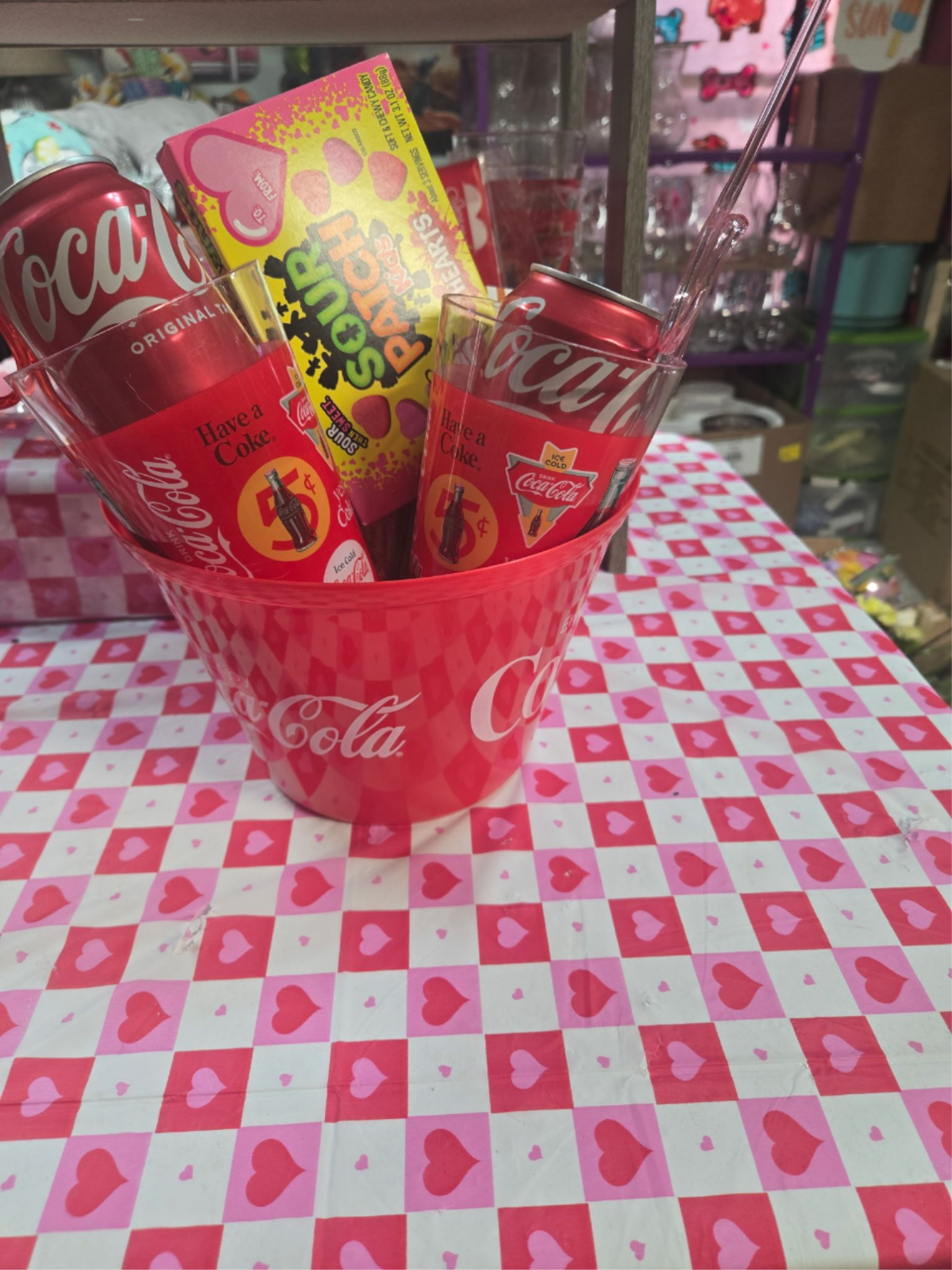Coca-Cola cans and candy in a pink heart-patterned bucket