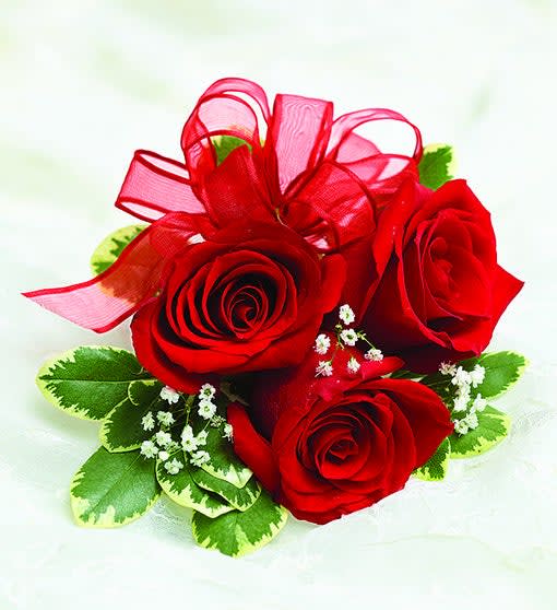 Three red roses with a red ribbon bow and small white filler flowers