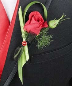 CF2168 - Putting On The Ritz Red Boutonniere  The Putting On The Ritz Red Boutonniere features: a Red Rose, Lily Grass, Sprig Ming Fern, Red Diamond Pin, and Black Sheer Ribbon.   Copyrighted content provided by FlowerShopNetwork.com Proud Member of Flower Shop Network