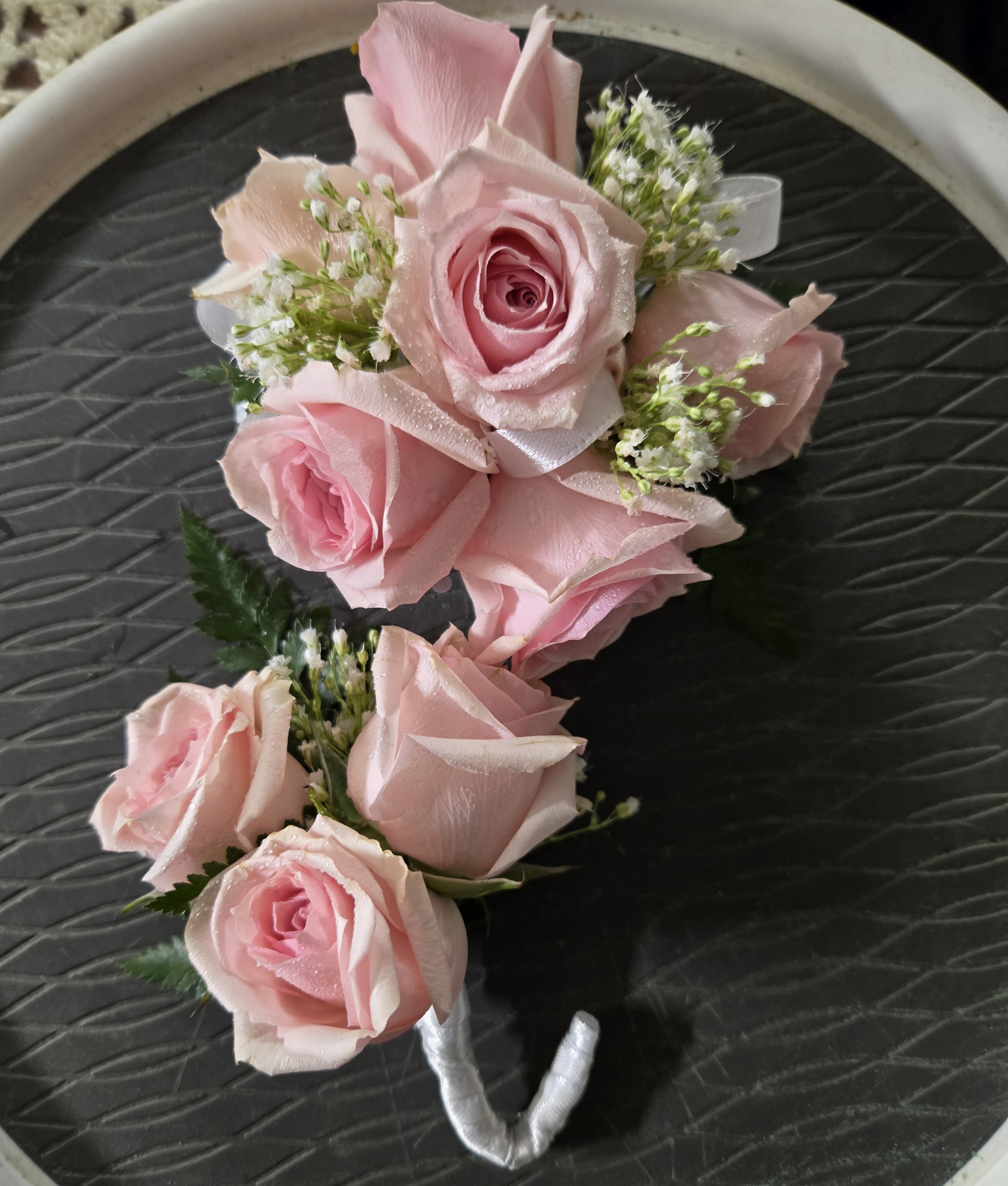 Pink rose boutonniere with small white filler flowers