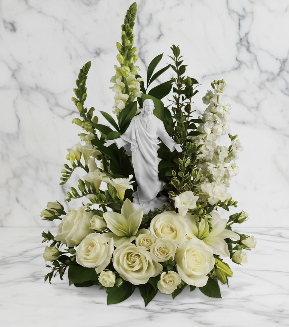White floral arrangement with a small statue in the center