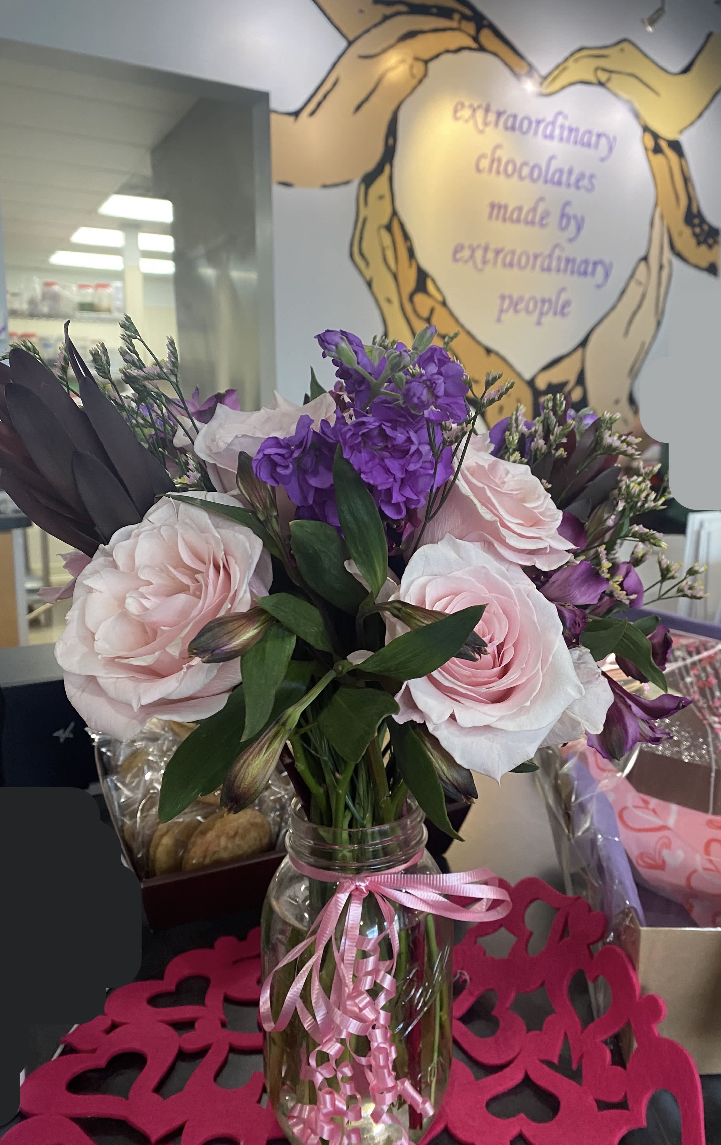 Pink and purple bouquet in a glass jar tied with a pink ribbon