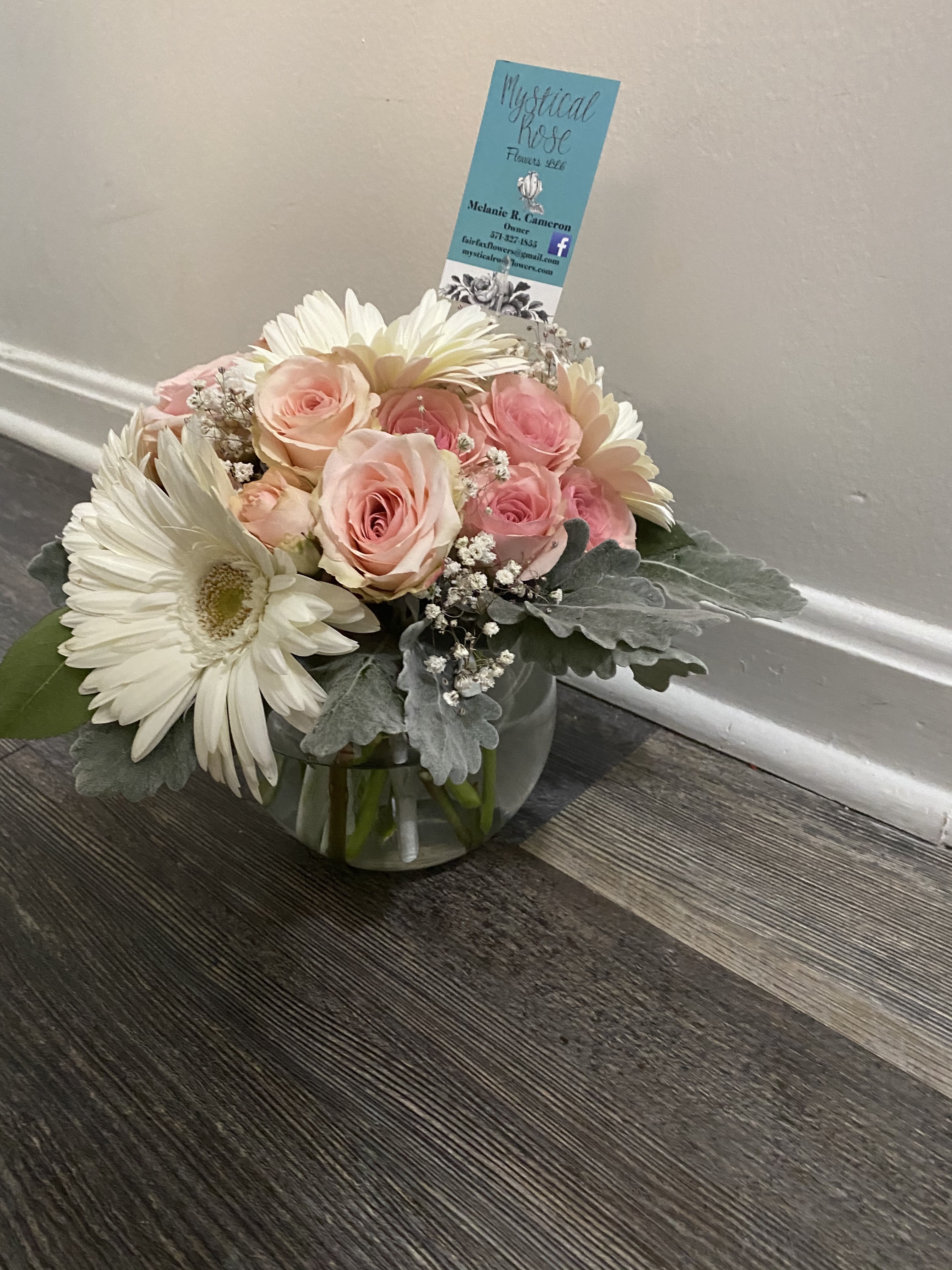 Pink roses and white daisies arranged in a glass bowl vase