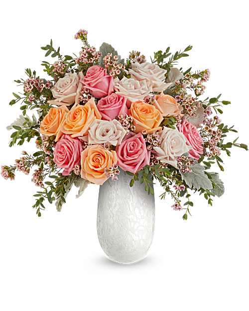 Opal Garden Bouquet  - Delight Mom with the Opal Garden Bouquet, a lush mix of peach and pink roses beautifully arranged in Amelia Vase. This elegant art glass keepsake adds soft shimmer and a fresh, heartfelt Mother's Day touch. Opal Garden Bouquet is a beautiful Mother's Day floral arrangement featuring light pink, peach, and pink roses, accented with pink waxflower, dusty miller, and parvifolia eucalyptus.   Approximately 20 1/2" W x 19 1/2" H