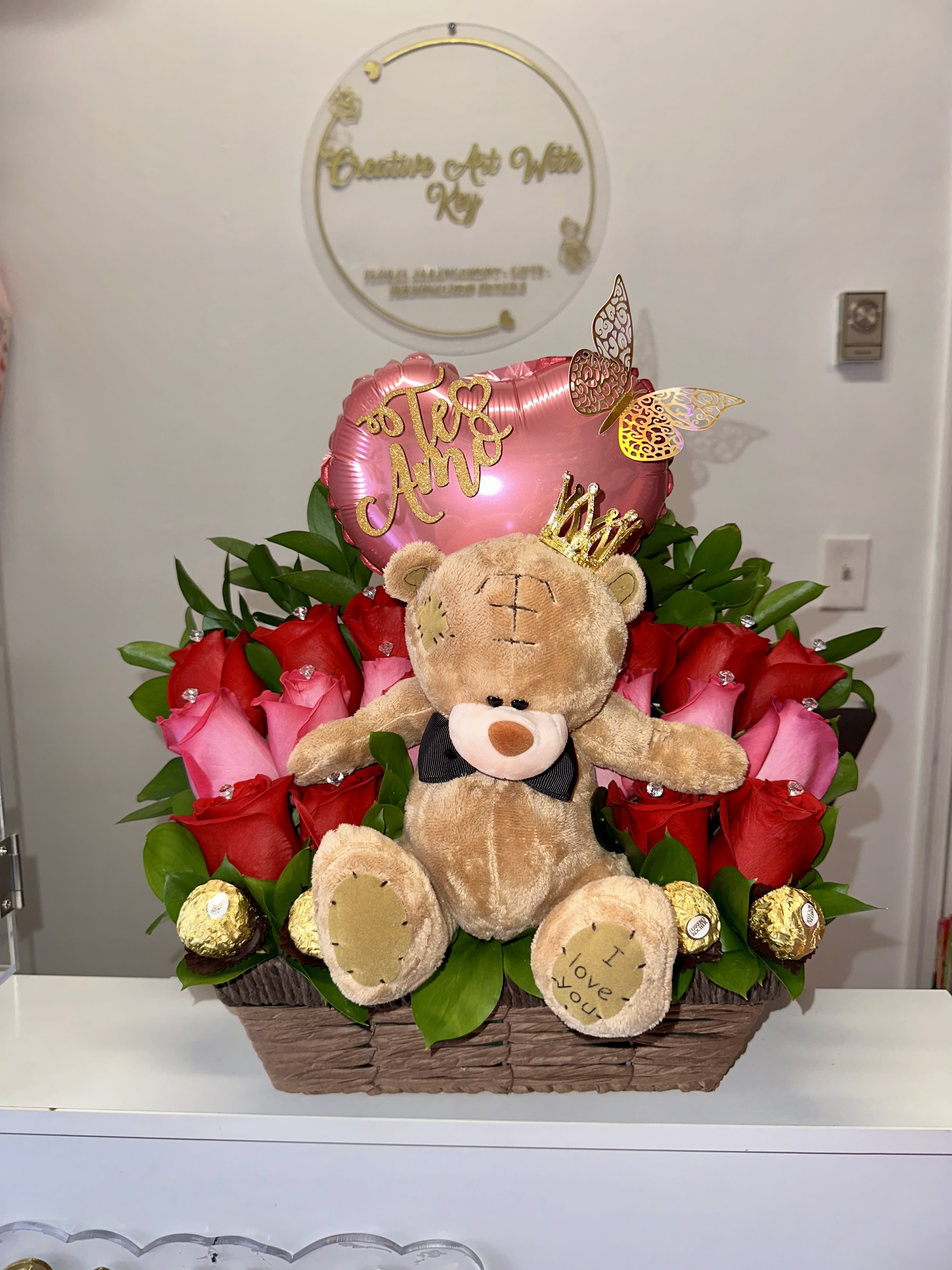 Basket arrangement of red and pink roses with a teddy bear and heart balloon