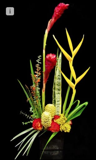 Tall tropical arrangement with red ginger, yellow heliconia, and roses in a black rectangular container.