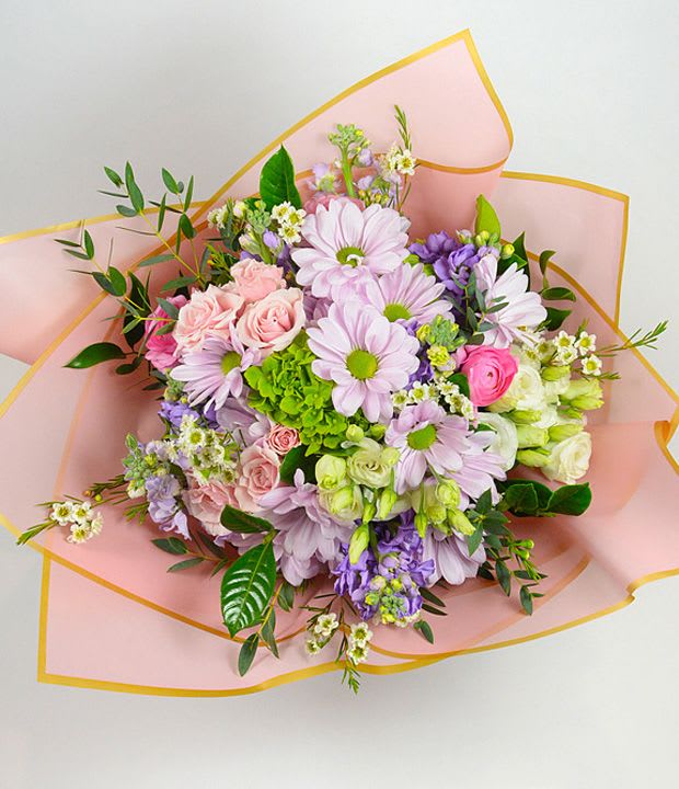 Bouquet of pink, lavender, and white flowers wrapped in pink paper