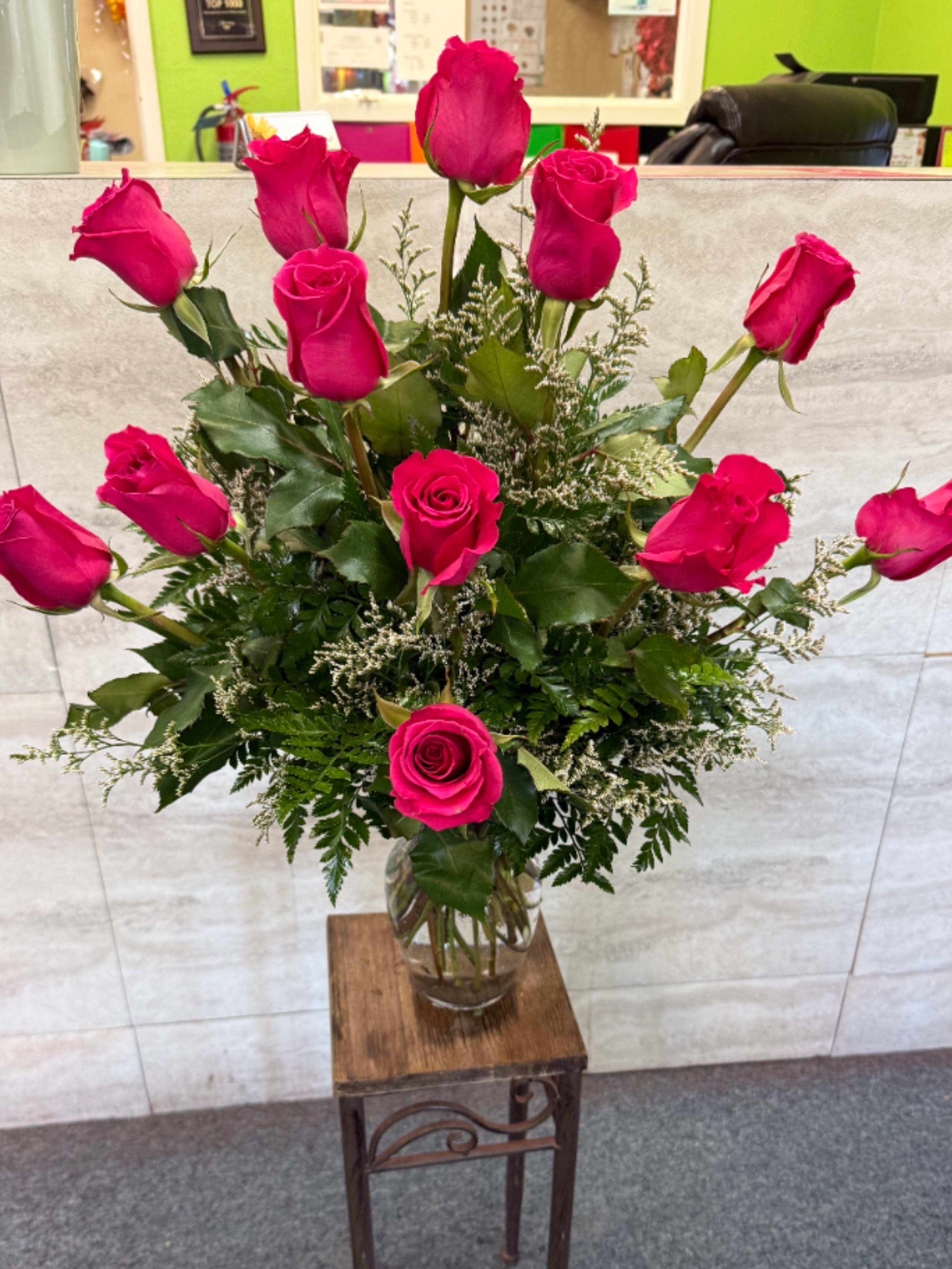 Tall bouquet of hot pink roses in a clear glass vase