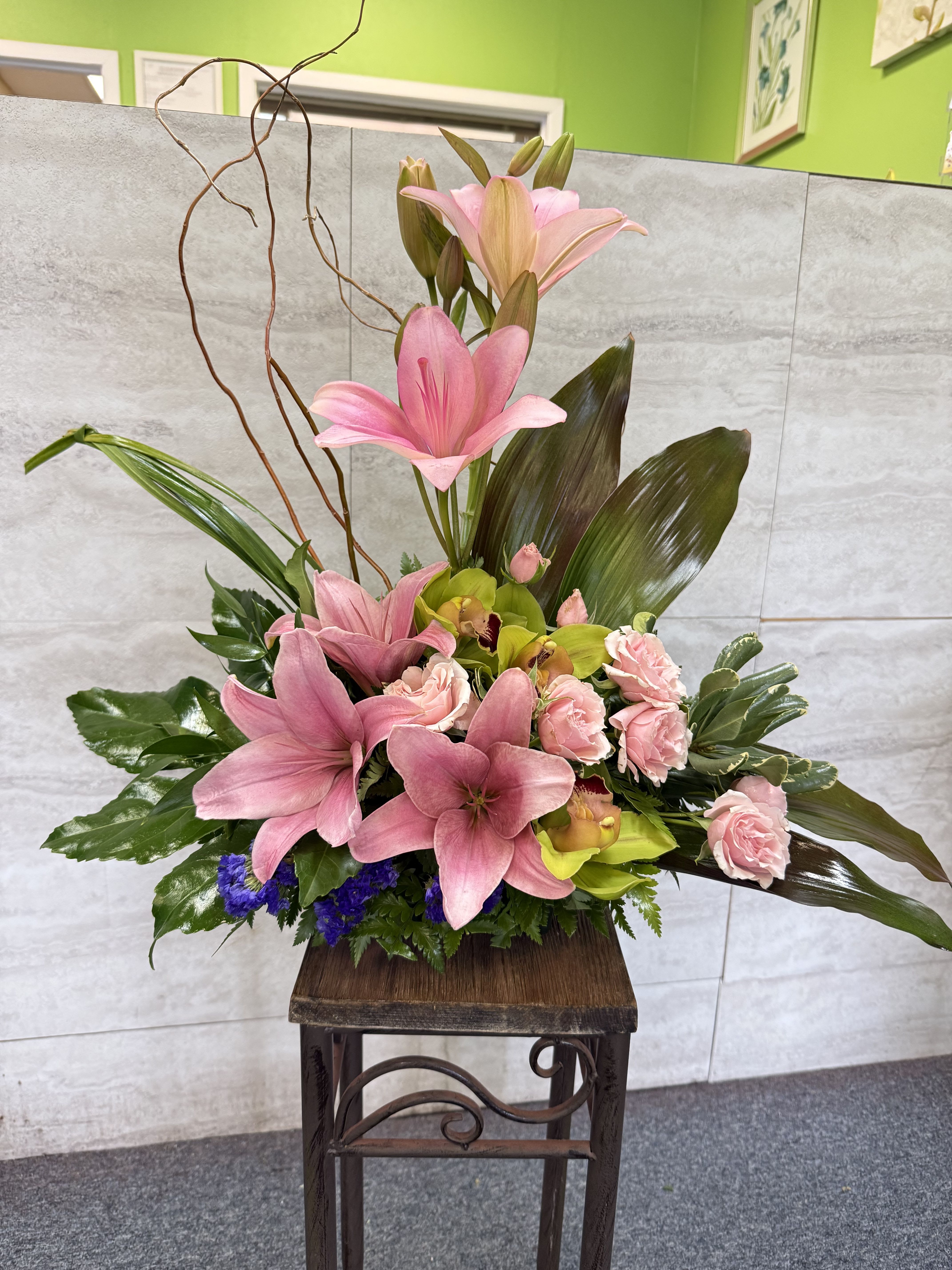 Imagination Blooms with Cymbidium Orchids - (ONE-SIDED) The exotic bouquet includes pink cymbidium orchids, light pink spray roses, pink Asiatic lilies and purple statice accented with ti leaves and other assorted greenery. Orientation: One-Sided