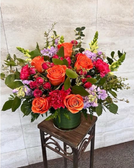 Shades of Summer  - (ONE-SIDED) Capture the essence of warm days with Shades of Summer, an enchanting flower design that brings together the vibrant colors of pink and orange. This elegant arrangement features a stunning mix of Roses, Carnations, Stock, Snapdragons, and premium foliage that complement each other perfectly. Presented in a leaf-lined cylinder vase, Shades of Summer is guaranteed to delight any recipient and add a touch of warmth and beauty to any space. Approximately 15” H x 13” W 