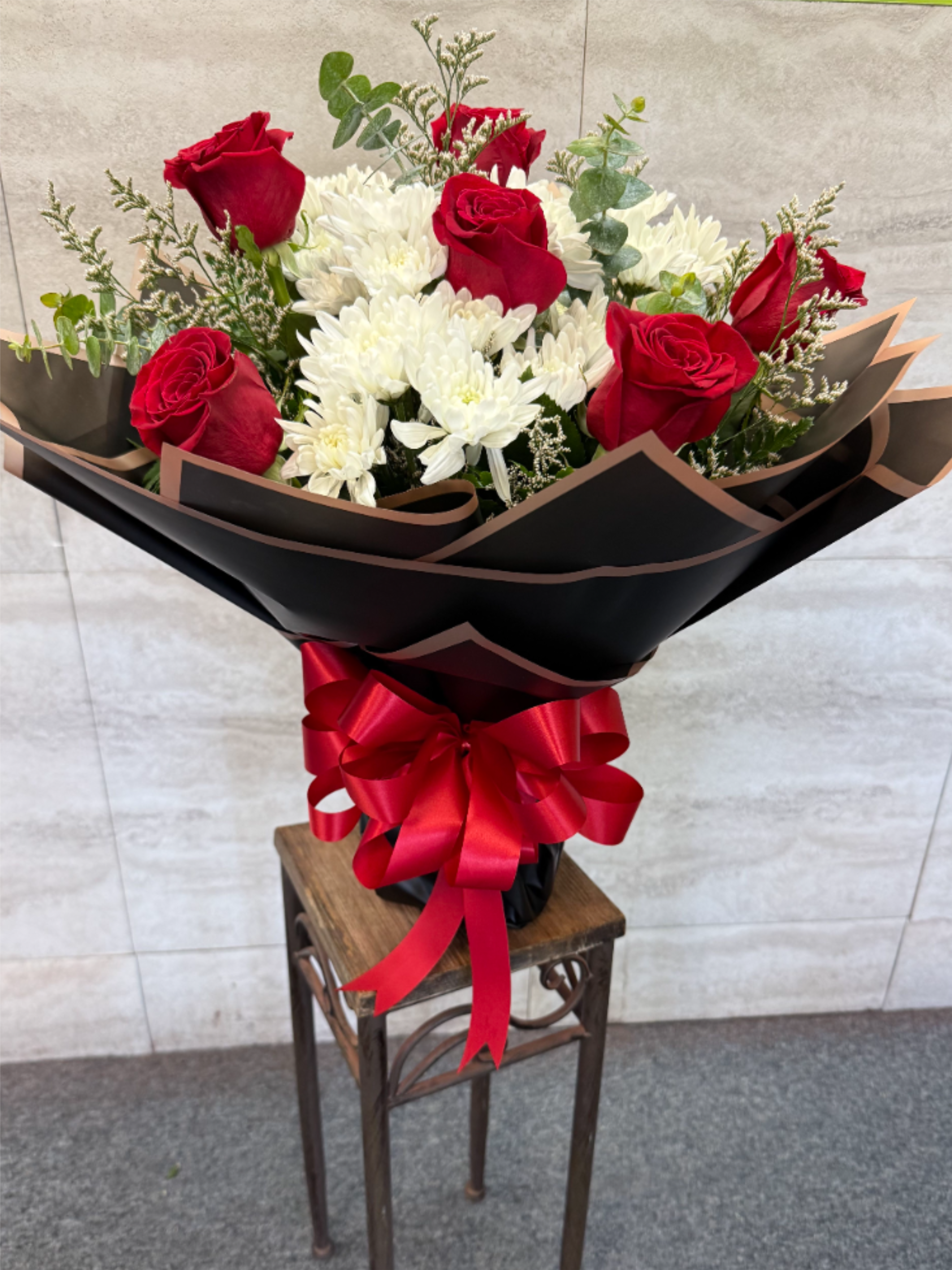 Grand Romance  - (WRAP- NO VASE) Red roses and soft white blooms with greenery, wrapped sleekly-classic, romantic bouquet perfect for anniversaries, Mother's Day or Valentine's Day to express deep love and devotion. 