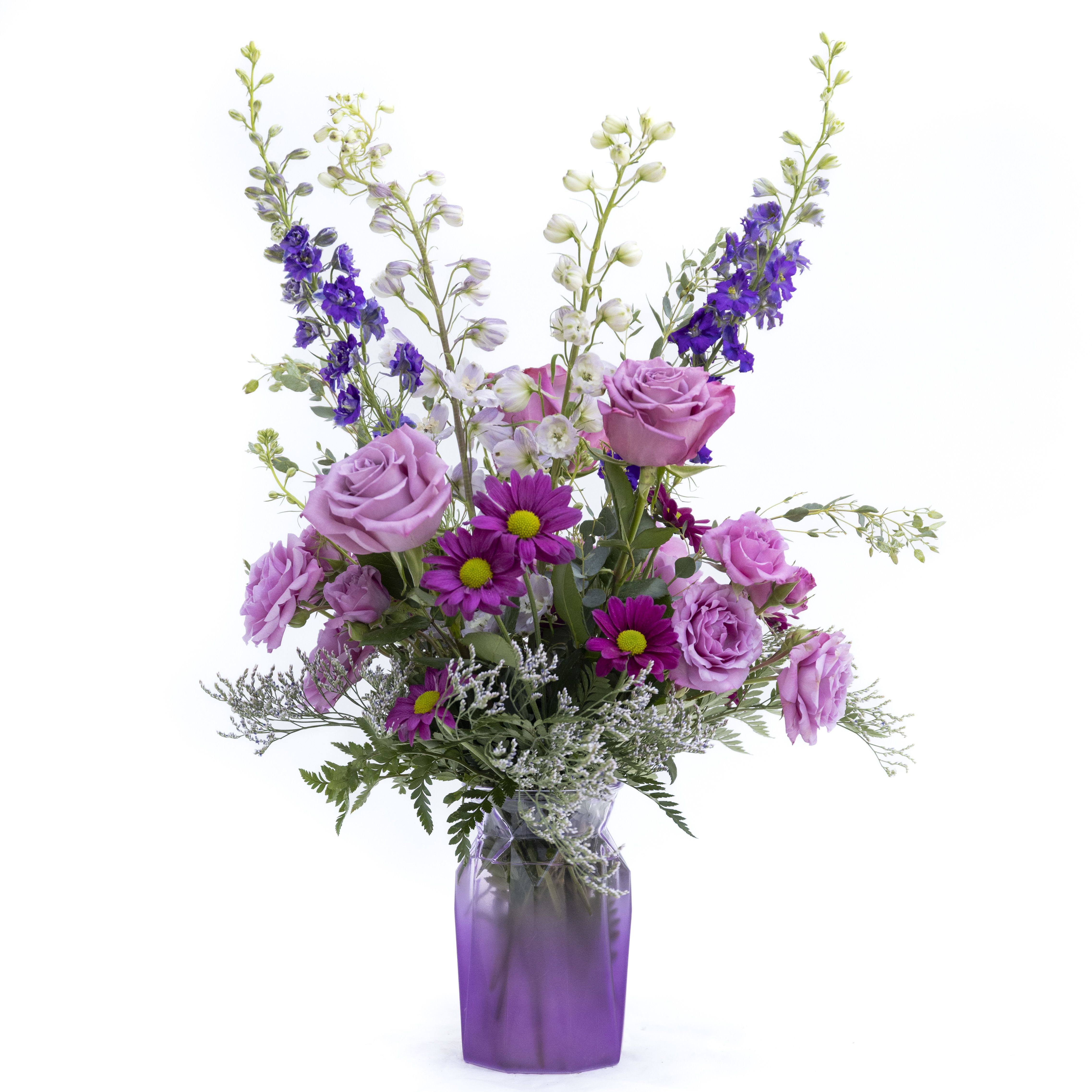 The Sophia - A perfect pix of purples arranged in a geometrically shaped vase. Purple Larkspur and Lavender delphinium bring your eye up through the arrangement white, Stunning purple roses and spray roses fill out the base. Accented with light and airy limonium for the whimsical touch.  Delivery to Syracuse, North Syracuse, East Syracuse, Dewitt, Manlius, Jamesville, Fayetteville, Camillus, Marcellus, Minor, Mattydale, Liverpool