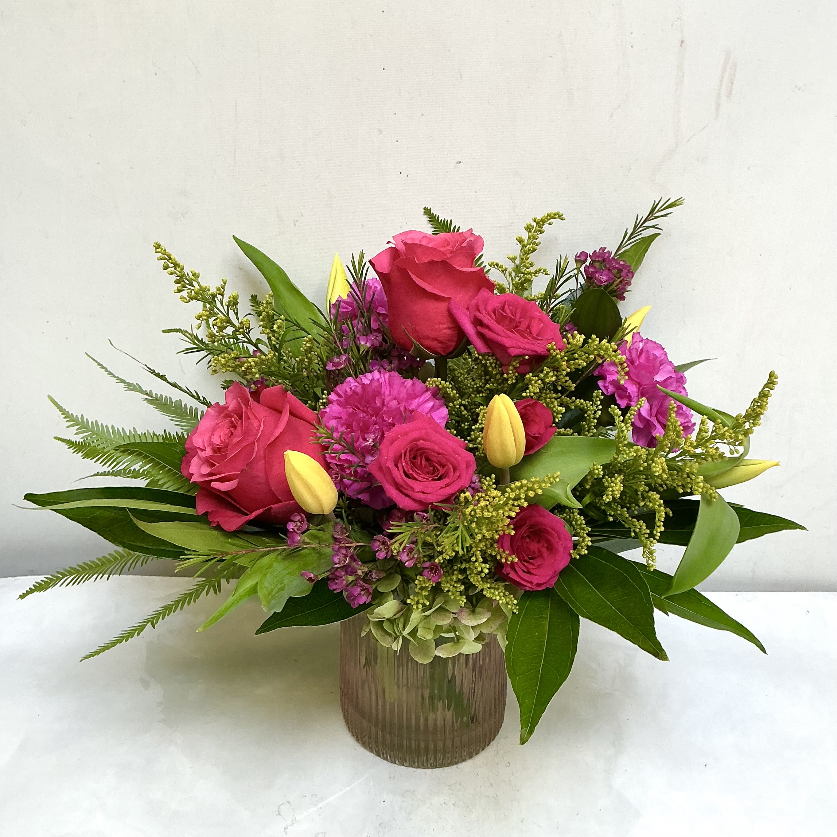 Raspberry Wishes - Bright pink roses paired with sunny yellow tulip buds make this Raspberry Wishes flower arrangement an instant mood-lifter - perfect as a birthday bouquet, a thank-you gift, or a cheerful everyday celebration arrangement. The energetic pink-and-yellow contrast reads like spring in full swing, and the lively composition assures the person you're thinking of will feel noticed and genuinely brightened.