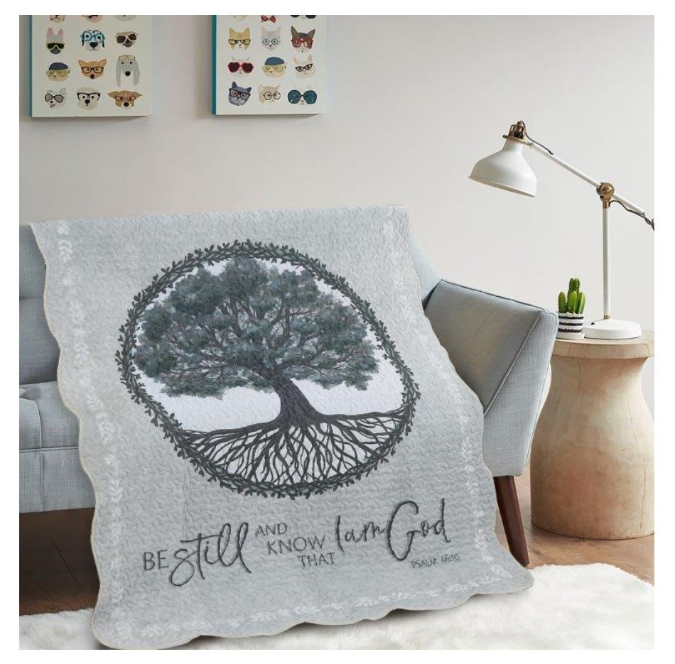 Tree-themed quilt draped over a sofa in a living room