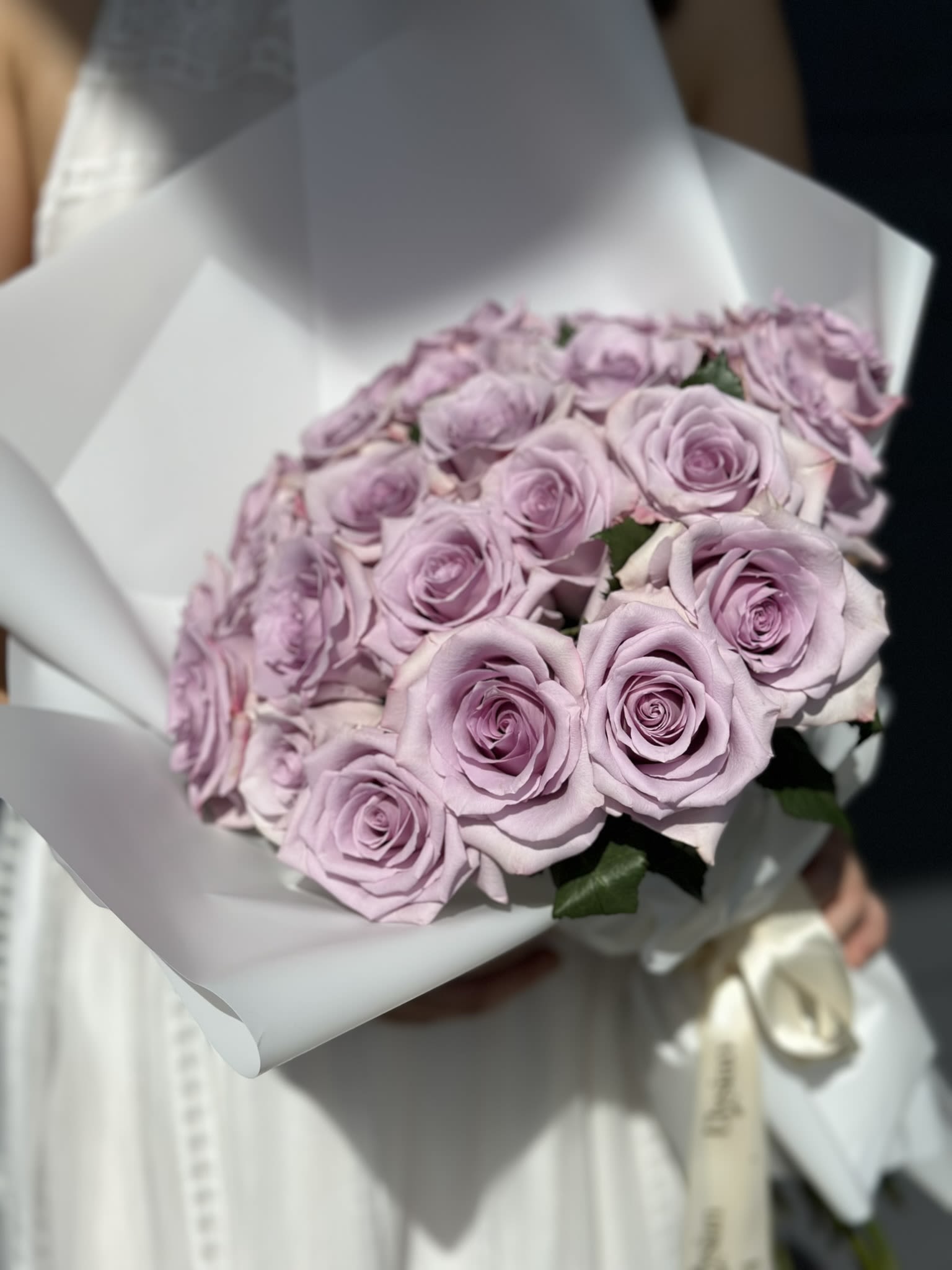 Lady Lavander - Purple roses symbolize enchantment and love at first sight — making them perfect for the one who changed your world.  Hand-selected for their fullness and freshness, each stem is artfully arranged to create a bouquet that feels both modern and timeless. Wrapped in our signature elegant presentation, this design is made to impress at first glance.  *Color tones may vary slightly depending on market availability.