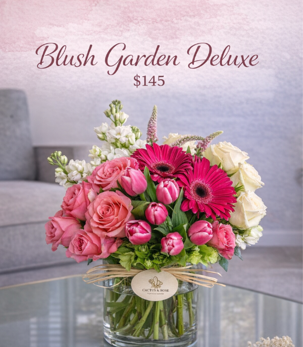 Elara Bloom - A refined, garden-inspired composition featuring blush roses, vivid gerbera daisies, and elegant tulips, thoughtfully arranged with fresh seasonal textures. This deluxe design brings together softness and bold color in a modern silhouette—crafted to elevate any space with effortless sophistication.