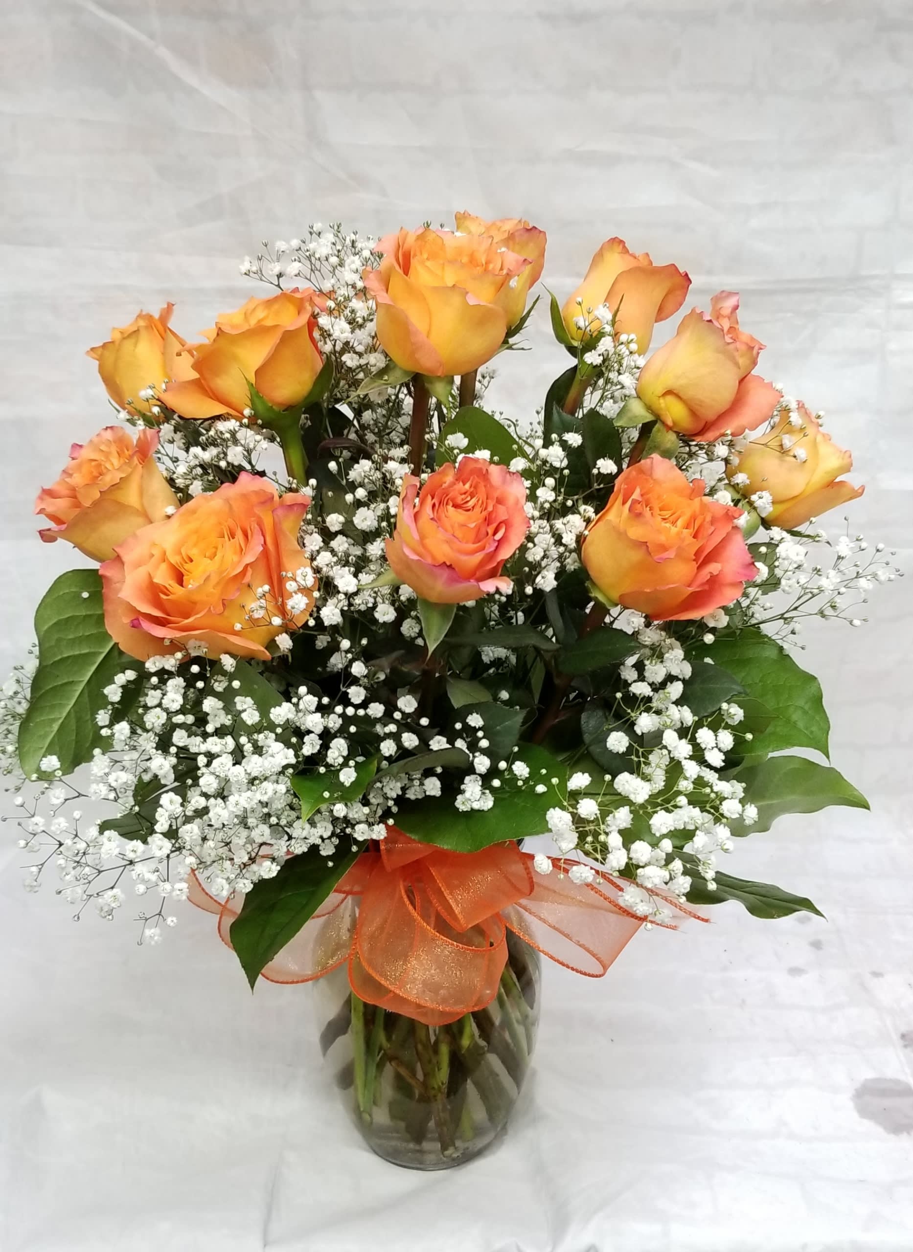 Long Stem Dozen Orange Roses - Select this Dozen orange roses arranged with babies breath in a clear glass vase.