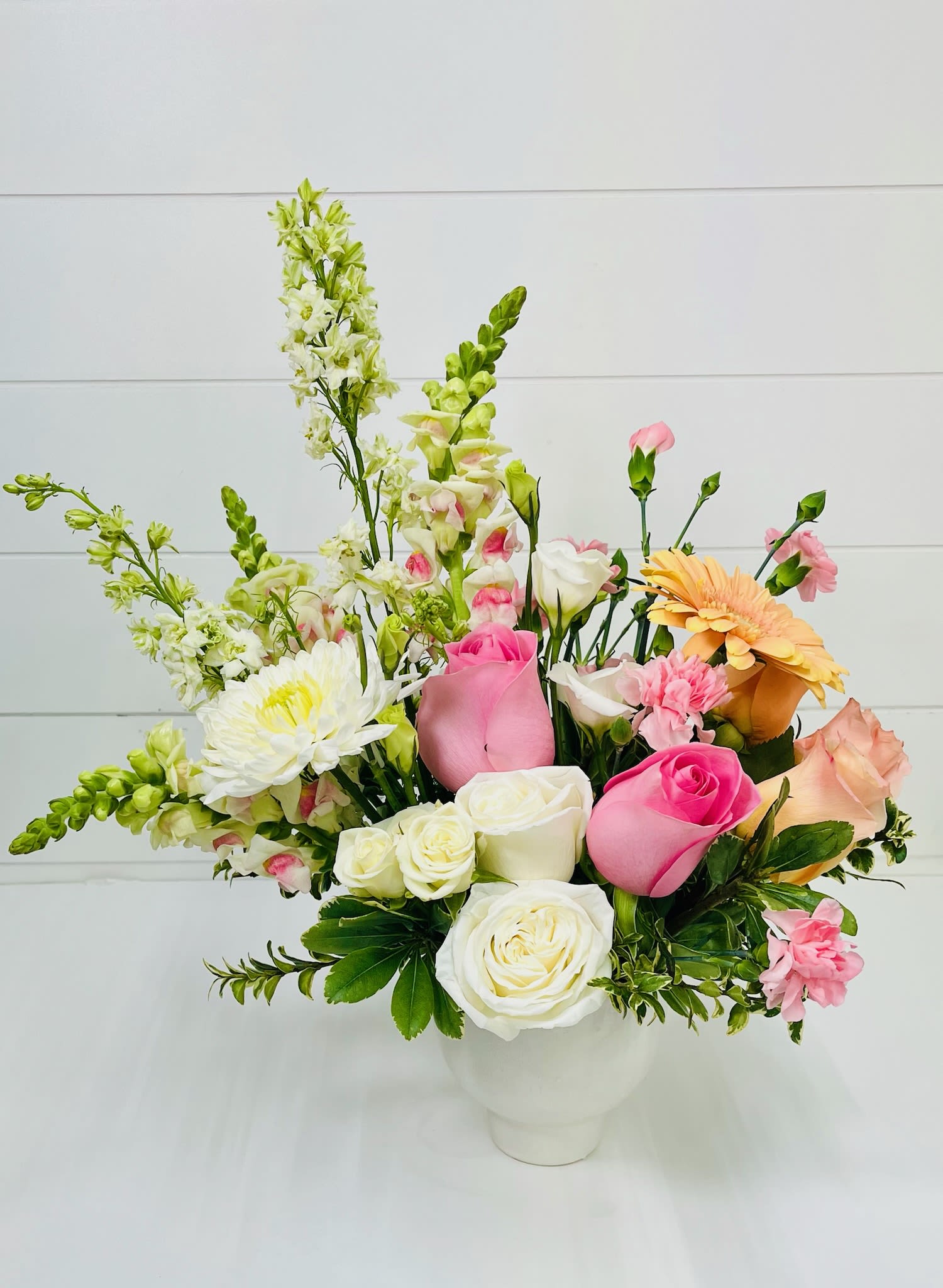 To Mom, With Love - Soft, delicate, and full of heartfelt beauty, To Mom, With Love is a gentle expression of appreciation and care. Designed in a romantic palette of soft pink and crisp white, this arrangement features a lush blend of chrysanthemums, roses, carnations, and cheerful gerbera daisies for a full, layered look.  Elegant stems of snapdragon and fragrant stock add height and softness, while touches of greenery keep the design fresh and airy. The combination of textures and blooms creates a graceful, garden-inspired feel that’s both timeless and comforting.  Perfect for Mother’s Day, birthdays, or simply to say “I love you,” To Mom, With Love is made for the mom who appreciates soft beauty and thoughtful gestures.  Delivery Available In: Smyrna, Marietta, Mableton, Austell, and Atlanta