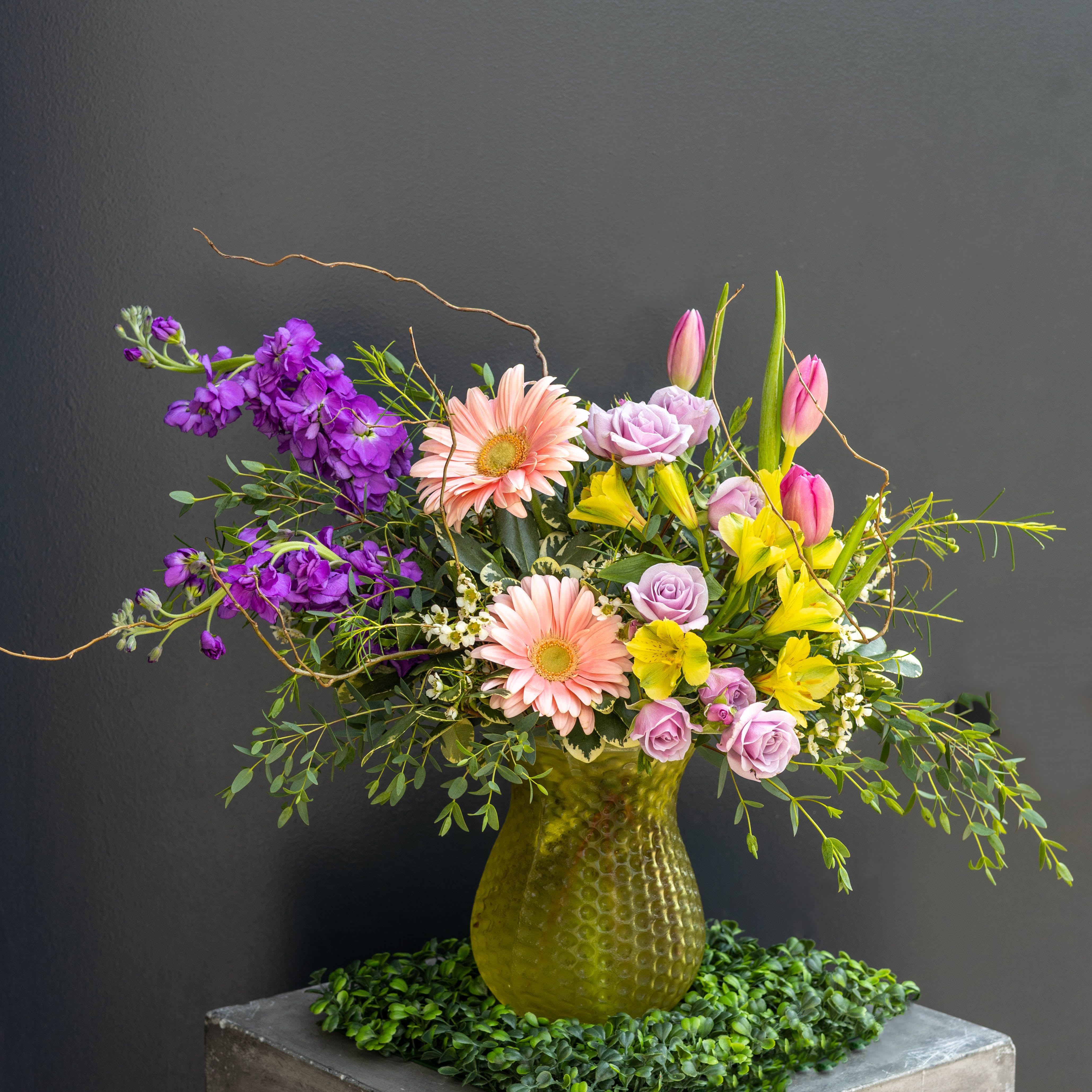 Lemon + Sage - Lemon + Sage is designed with the feeling of soft sunlight, garden air, and a hint of wild elegance in a glass yellow vase is a fresh celebration of spring in full bloom.  Designed with movement and intention, each stem reaches and wanders as if freshly gathered from the garden which creates a sense of lightness, whimsy, and quiet elegance. Accents of soft citrus hues bring warmth and brightness, while muted greens ground the design with an organic, sophisticated finish.  Perfect for brightening a home, celebrating the season, or sending a thoughtful gesture, Lemon + Sage captures the beauty of spring in its most graceful form.