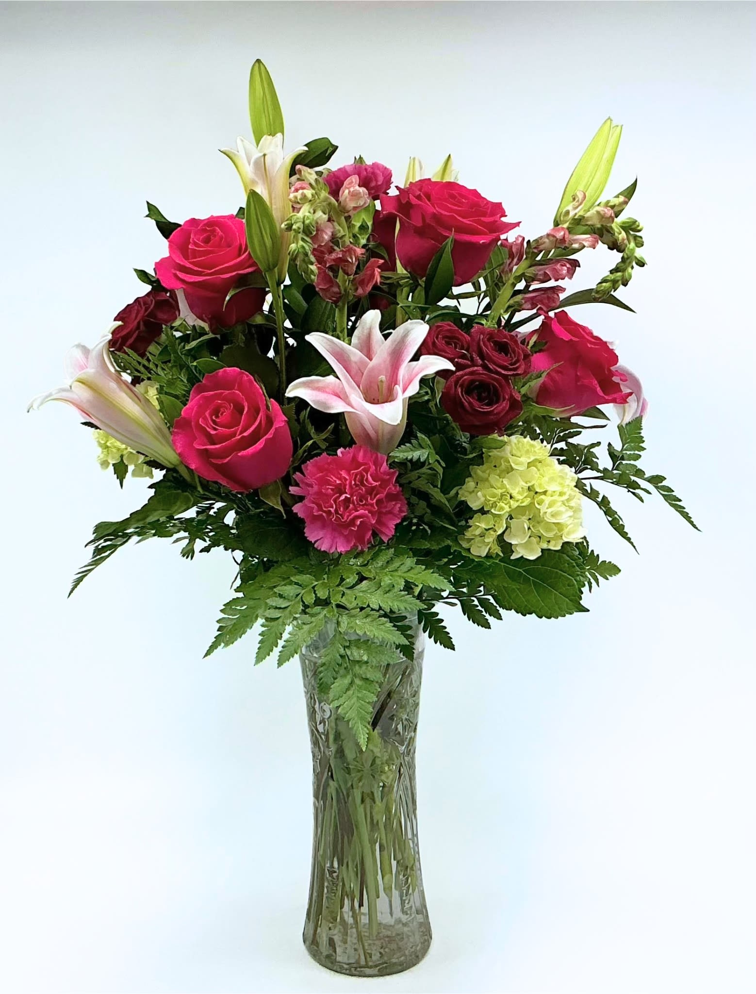 Rosy Delight - Hot pink roses, pink lilies, lime green hydrangeas, and snapdragons arranged in a tall clear glass vase. Ideal for birthdays, anniversaries, or sending a bright "thinking of you" message, Rosy Delight arrives ready to impress. 