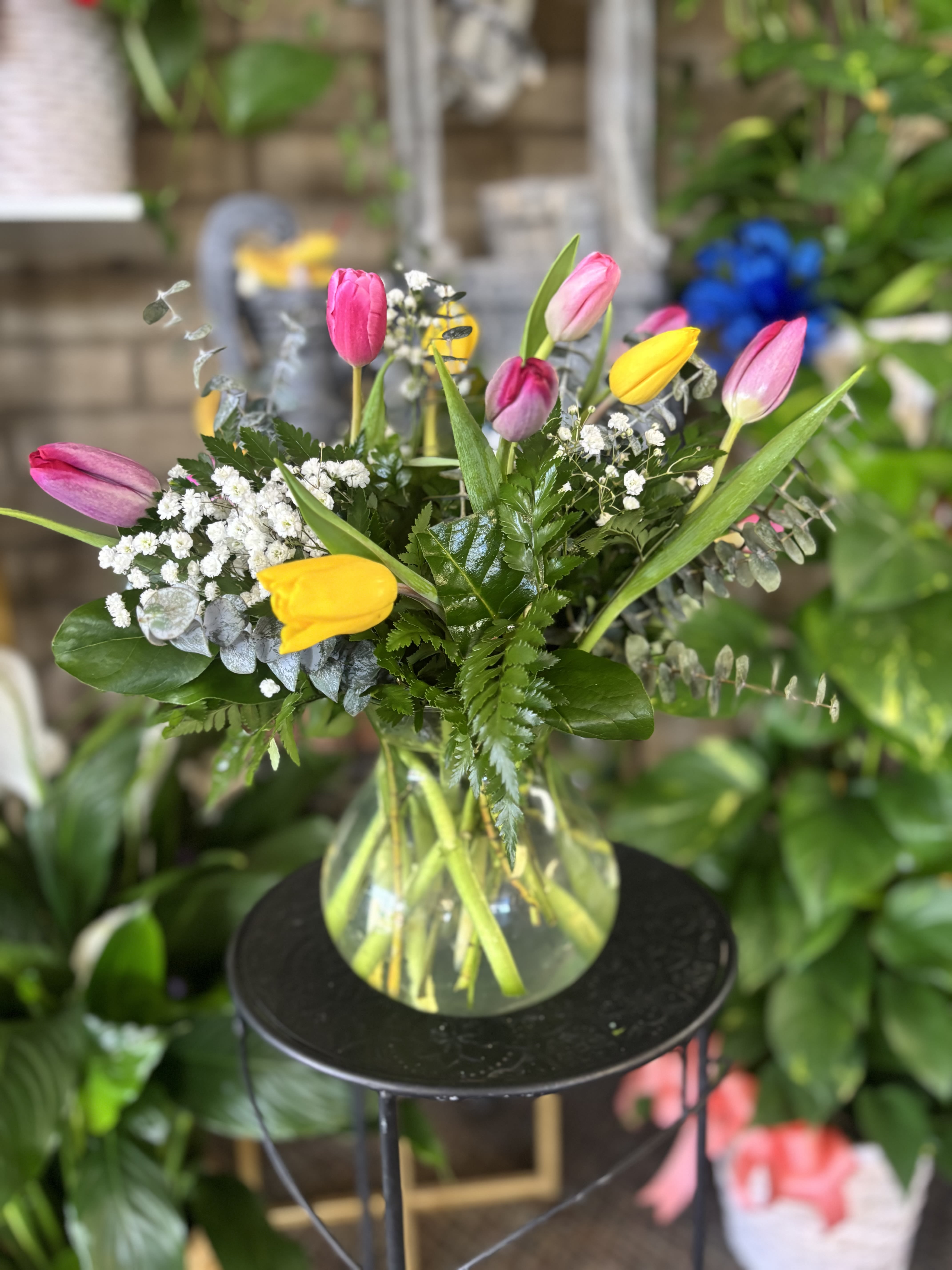 Bouquet of pink and yellow tulips in a clear glass vase