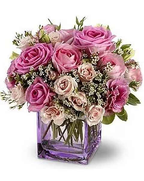 Teleflora's Rose Confection - Fragrant lavender and pink roses create a sweet treat when nestled together with frilly lisianthus and tiny white blossoms in a spectacularly pretty bouquet. This pink rose confection will be hand-delivered with care in a lavender glass vase.