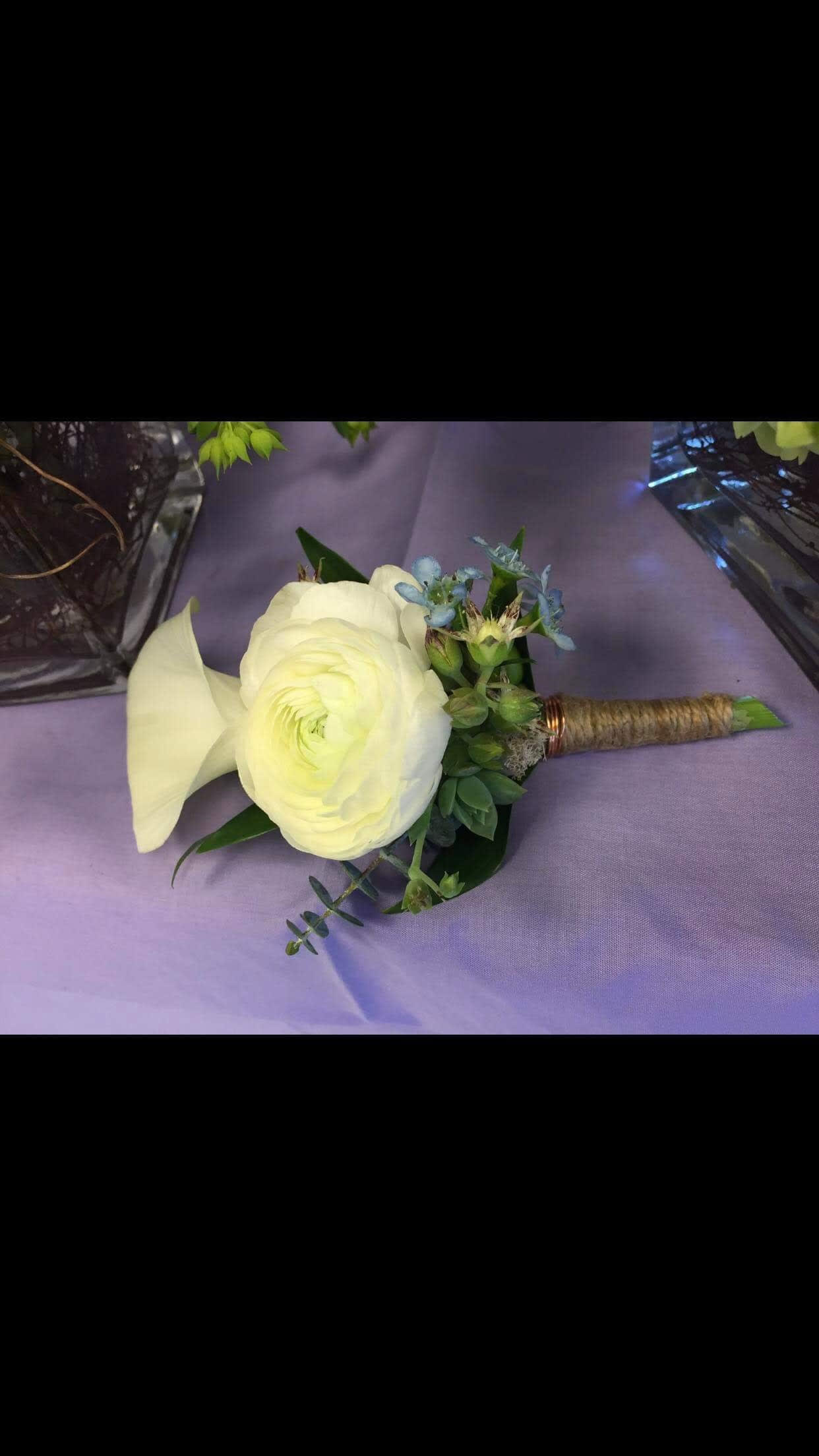 White calla lily and ranunculus boutonniere with blue accents