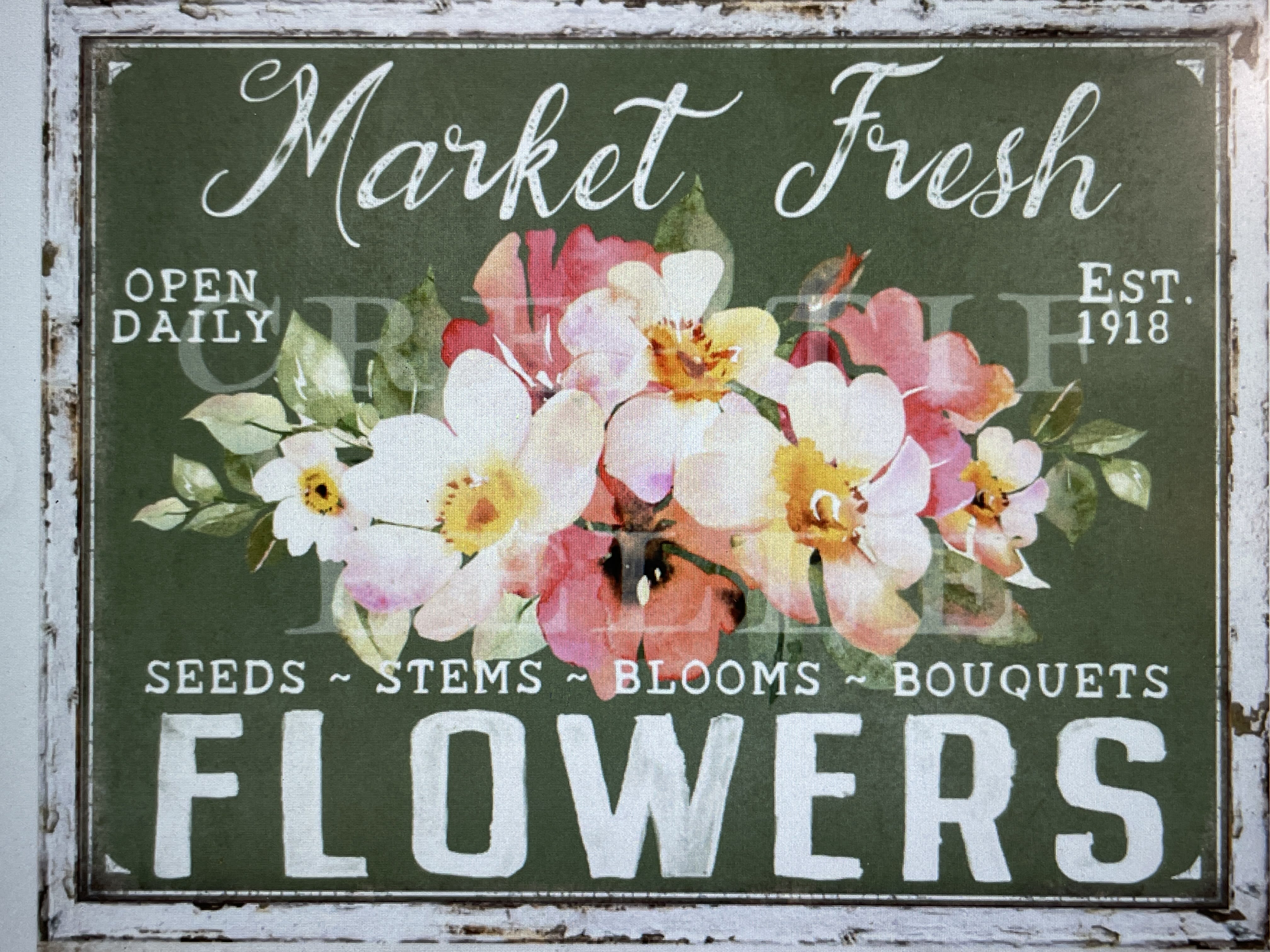 Floral shop sign with painted pink and white flowers on a green background