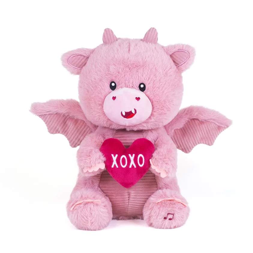 Pink plush dragon holding a red heart with XOXO text