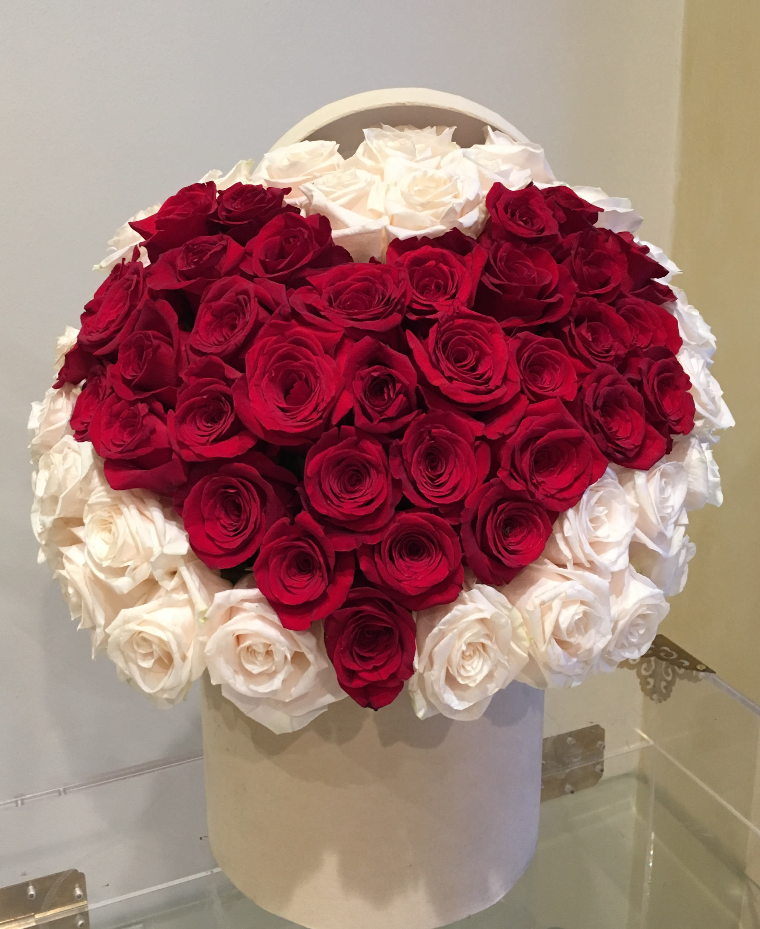 Heart-shaped bouquet of red and white roses in a white box