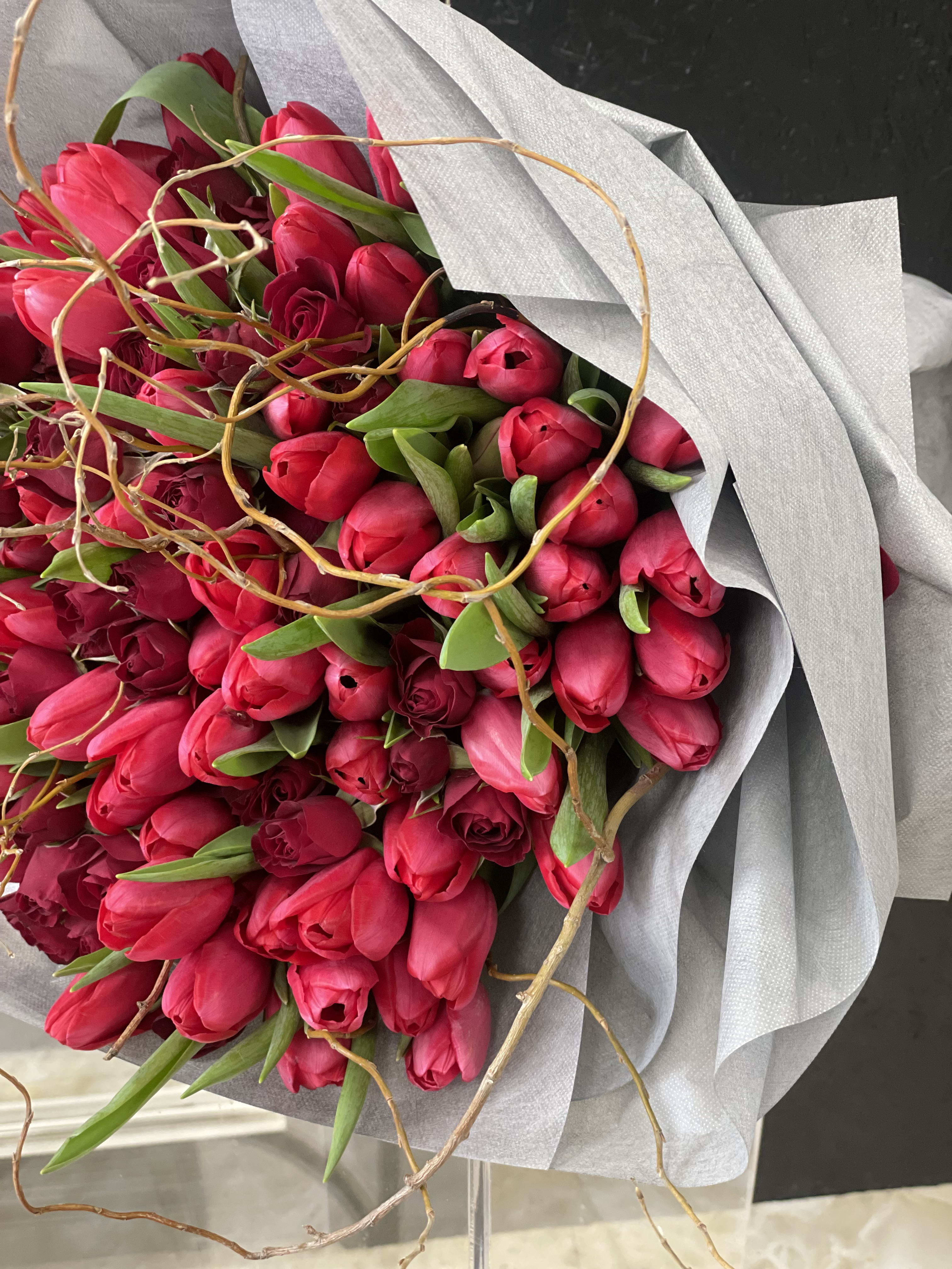 Bouquet of bright pink tulips wrapped in silver paper