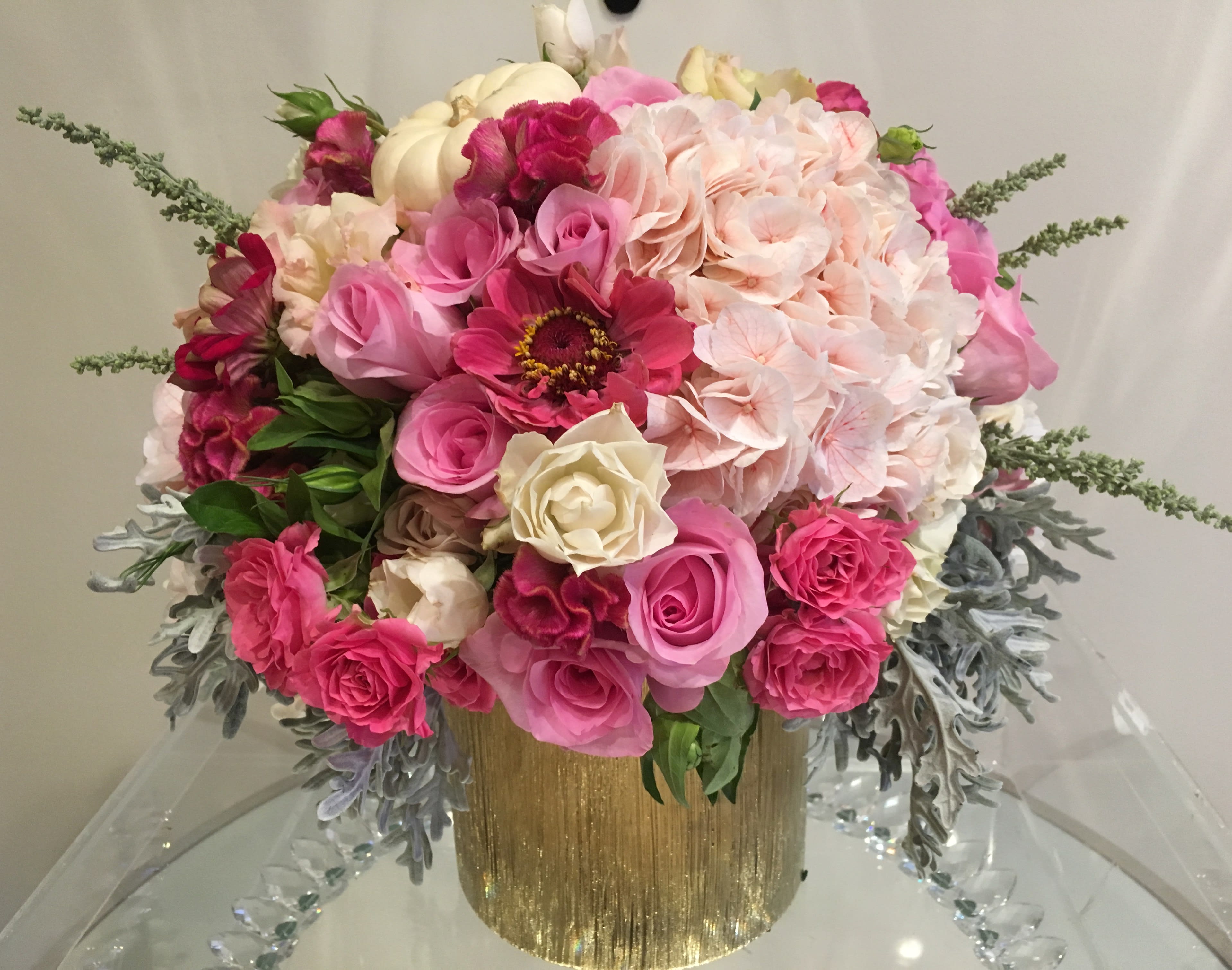 Pink and cream floral arrangement in a gold vase