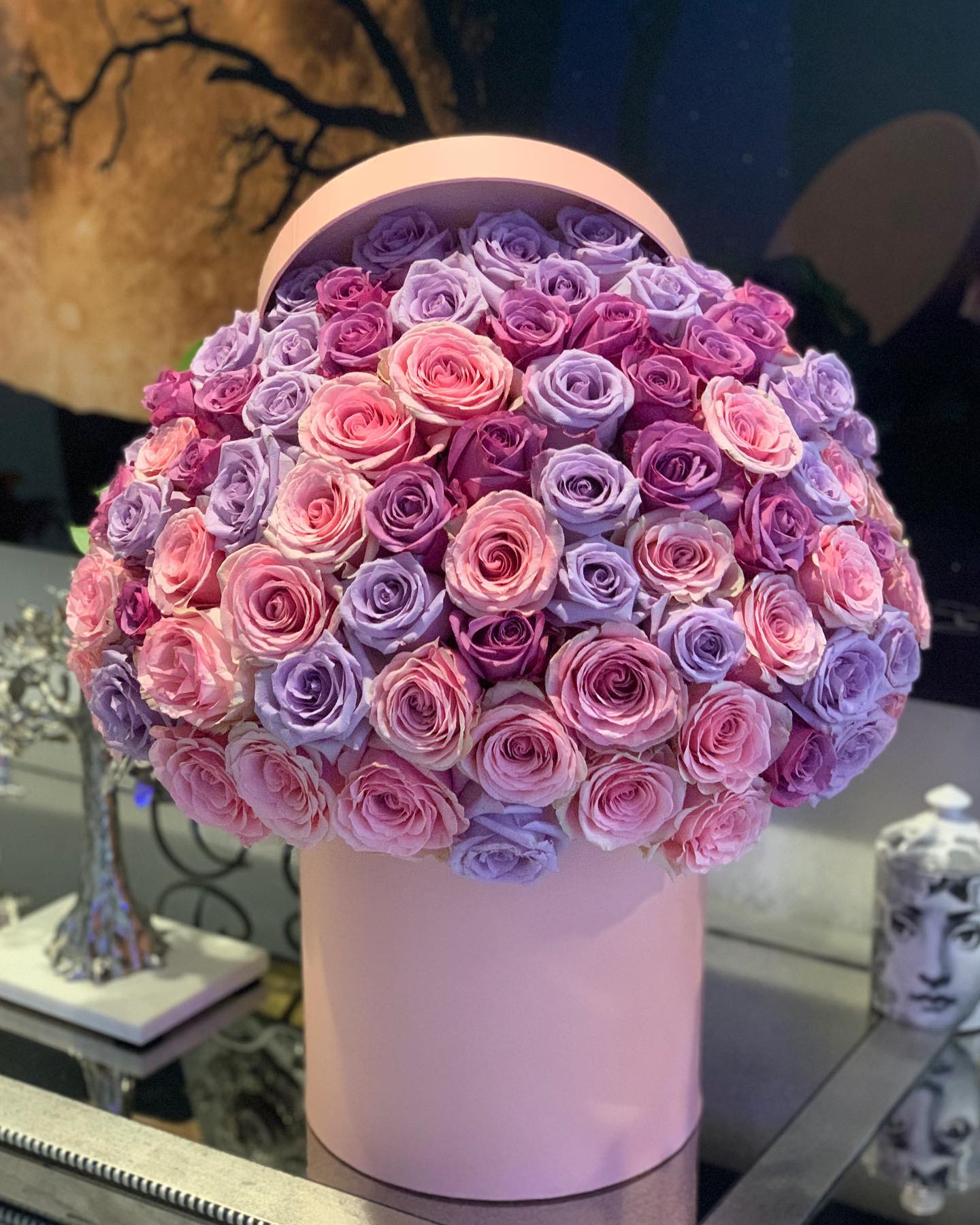 Round bouquet of pink and lavender roses in a pink hat box