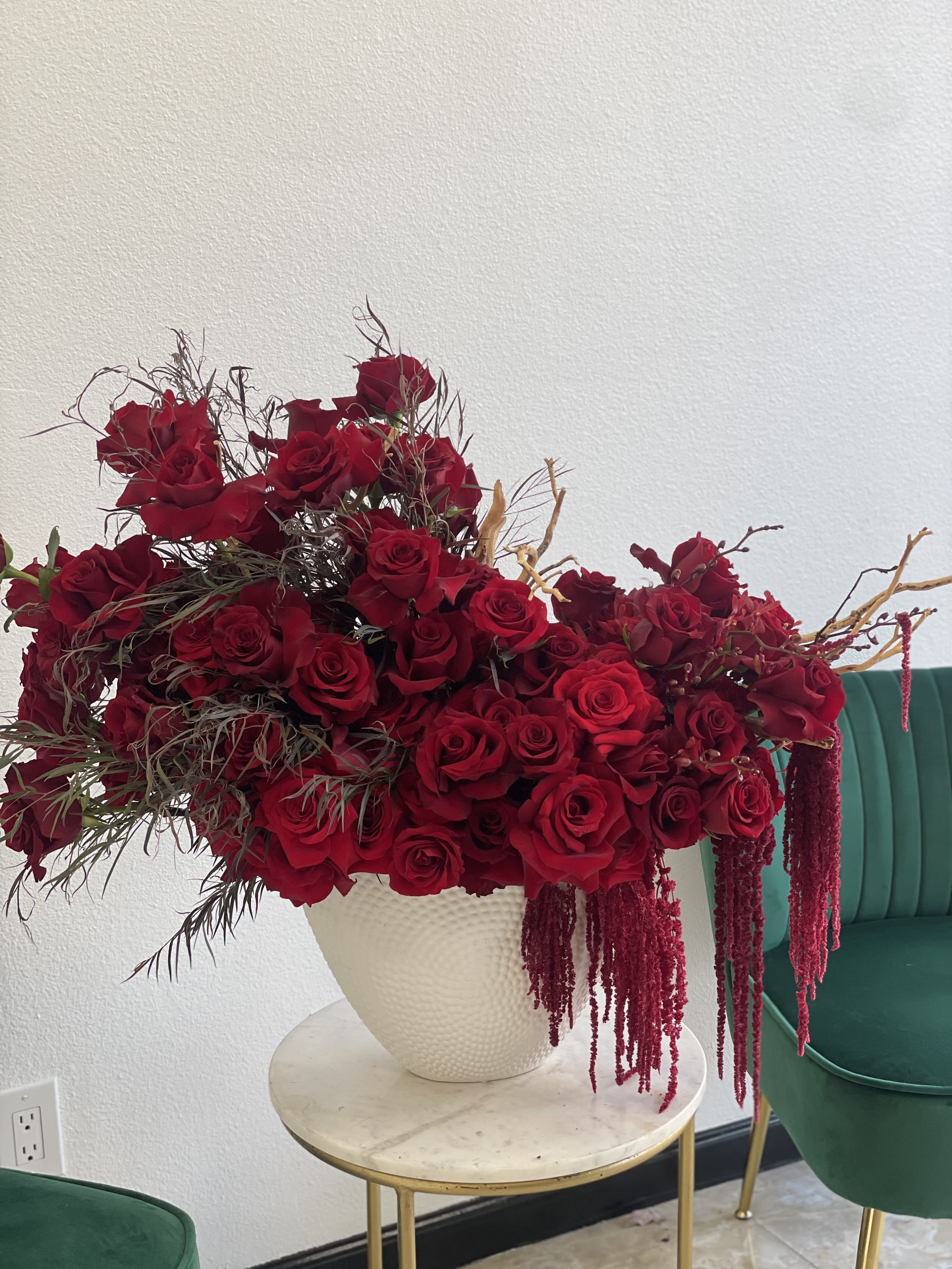 Large arrangement of red roses in a white vase