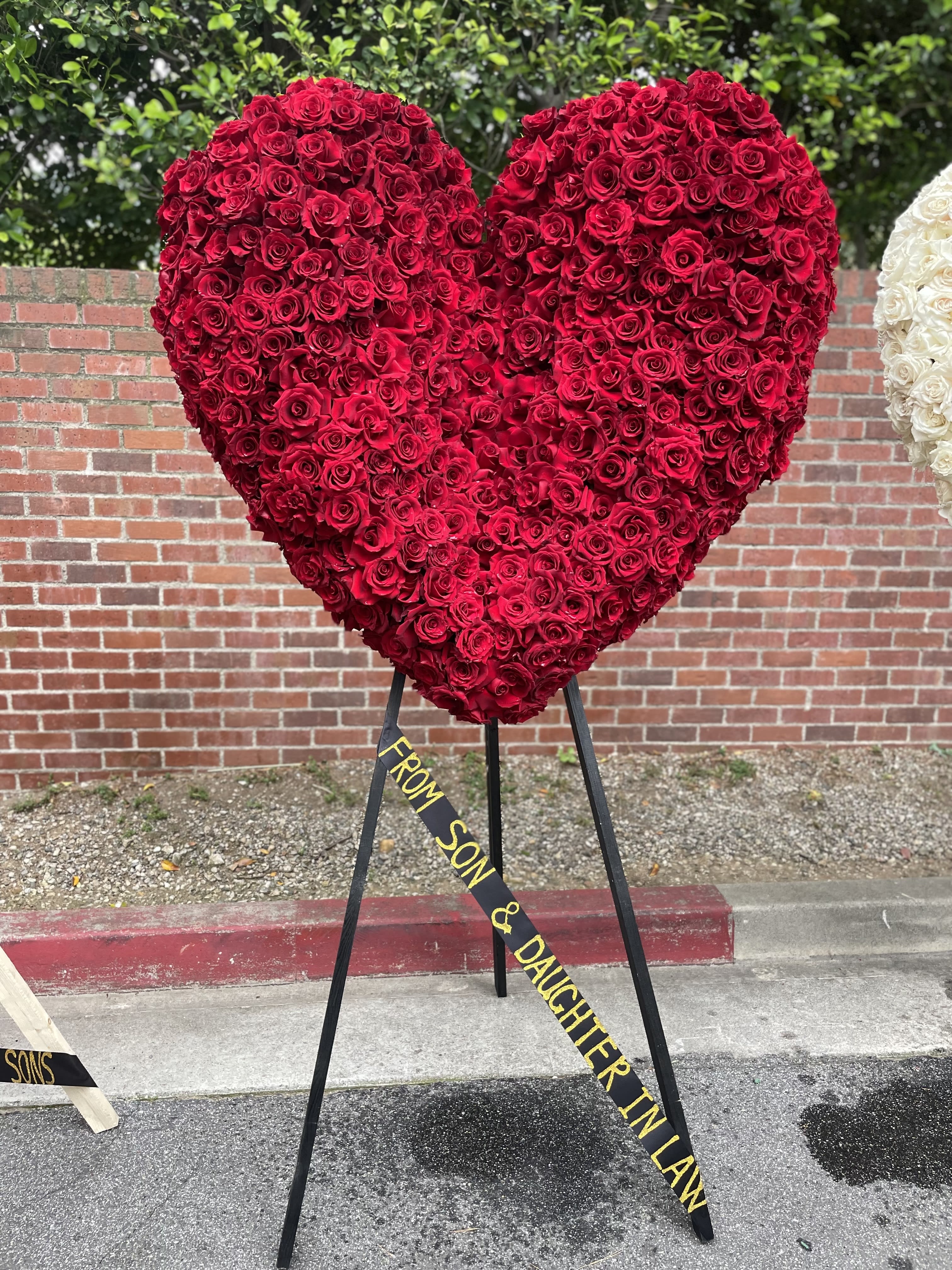 Large heart-shaped red rose arrangement on a stand