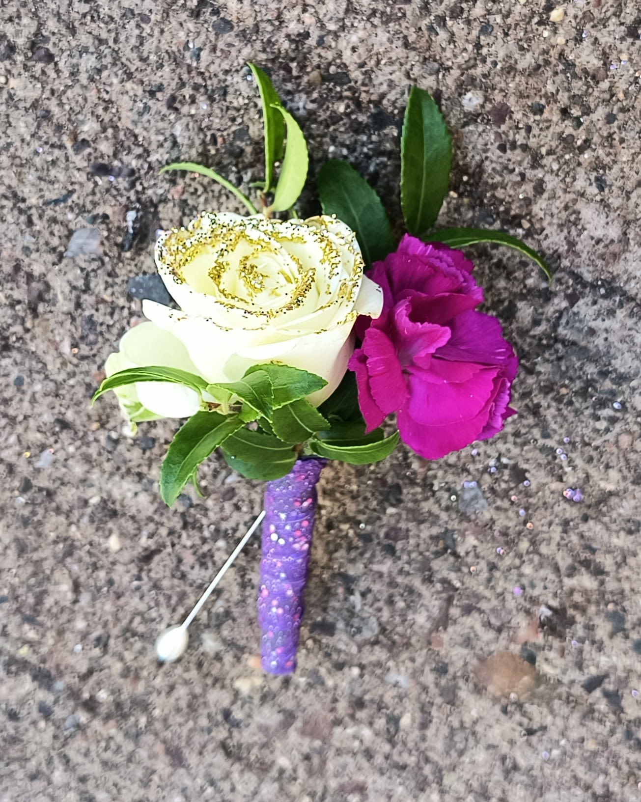 Boutonniere with white rose and magenta carnation on a purple glitter stem
