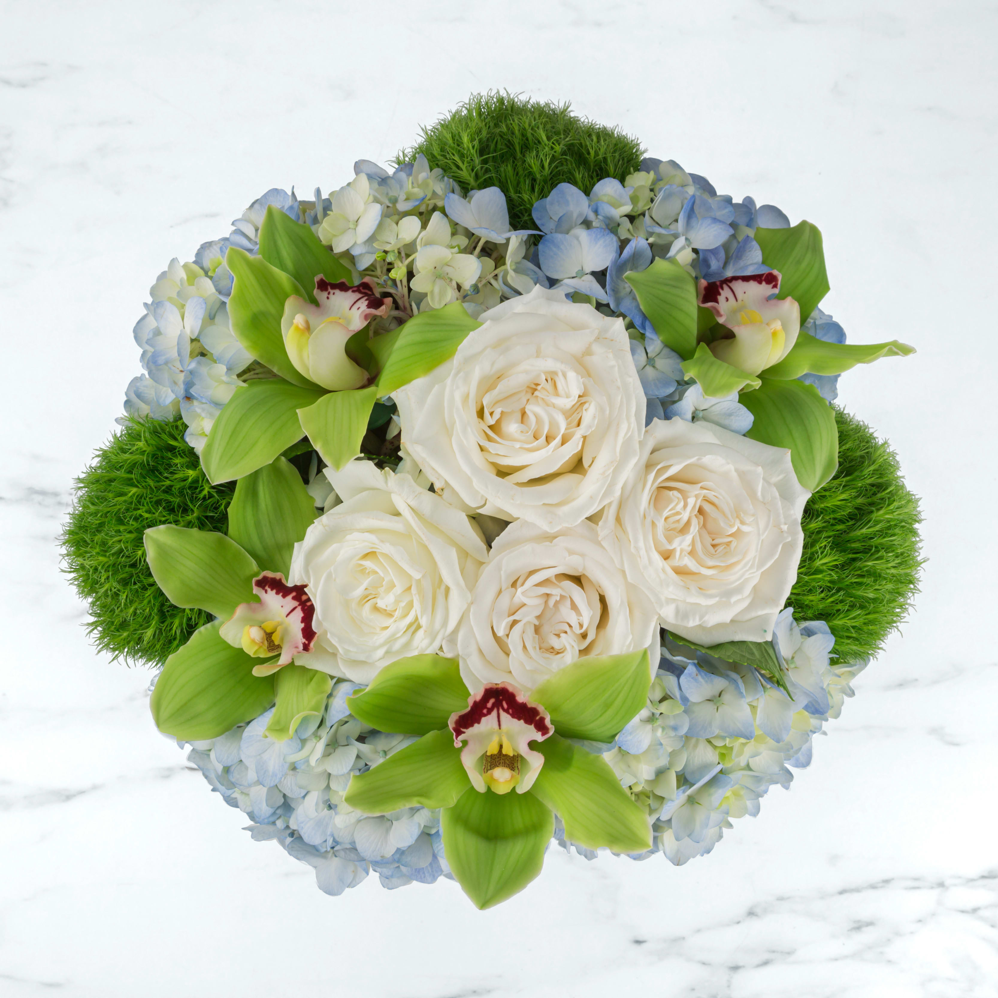Round bouquet of white roses, blue hydrangeas, and green orchids