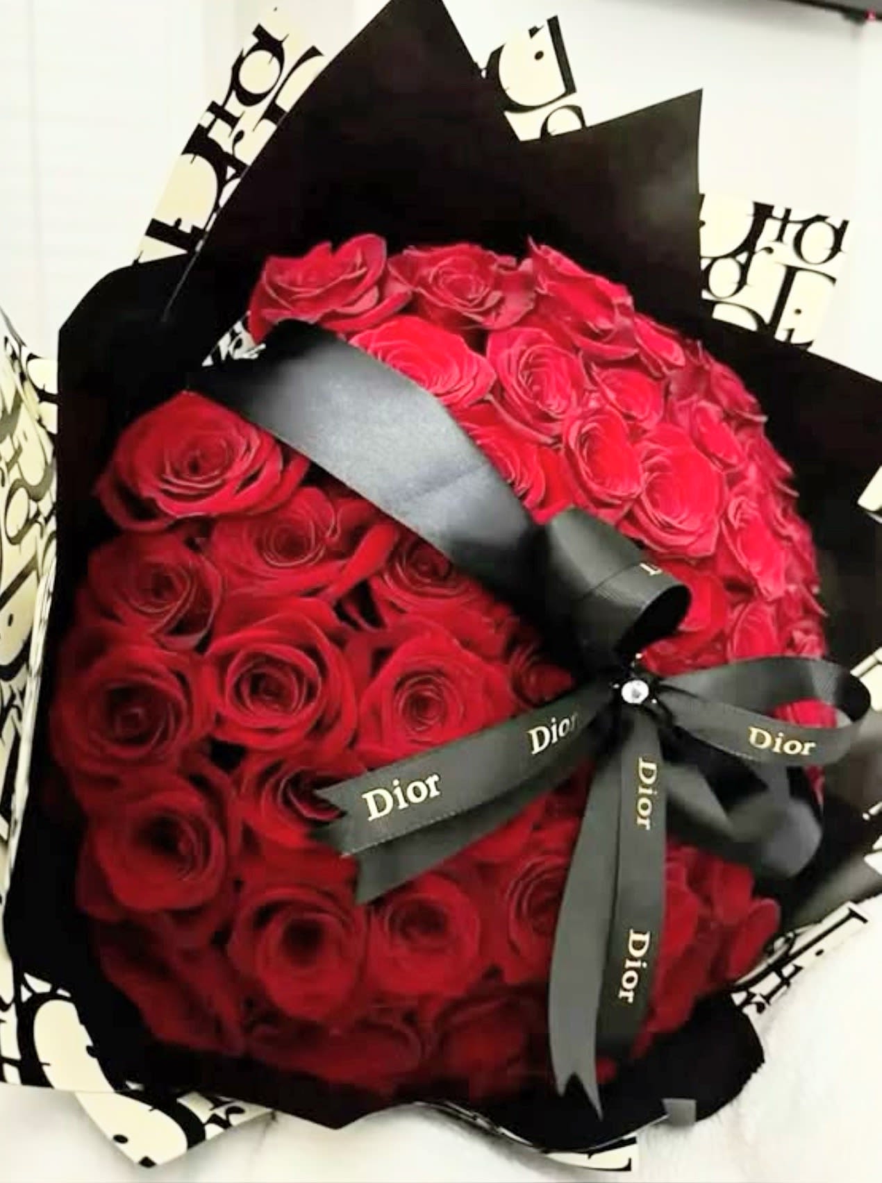 Corazon Dior Passion - Impactante ramo de rosas rojas adornado con un papel de lujo Dior