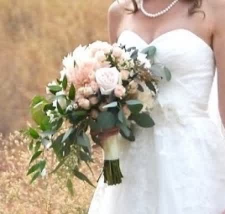 Bride holding a white and blush bouquet with greenery