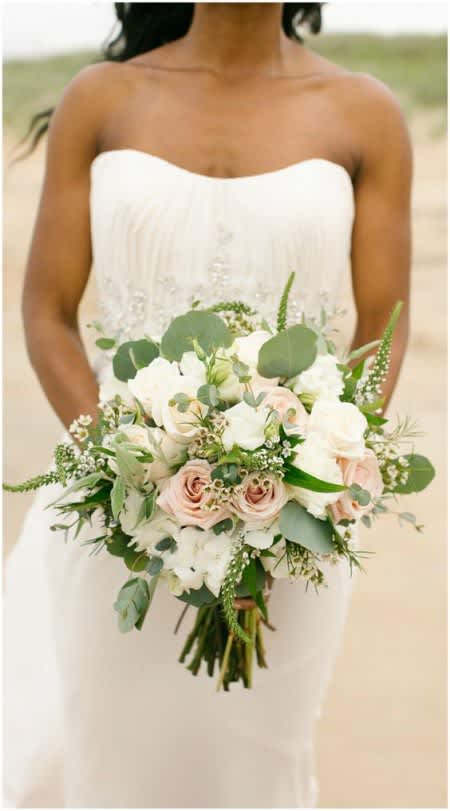 Bride holding a white and blush bouquet with greenery