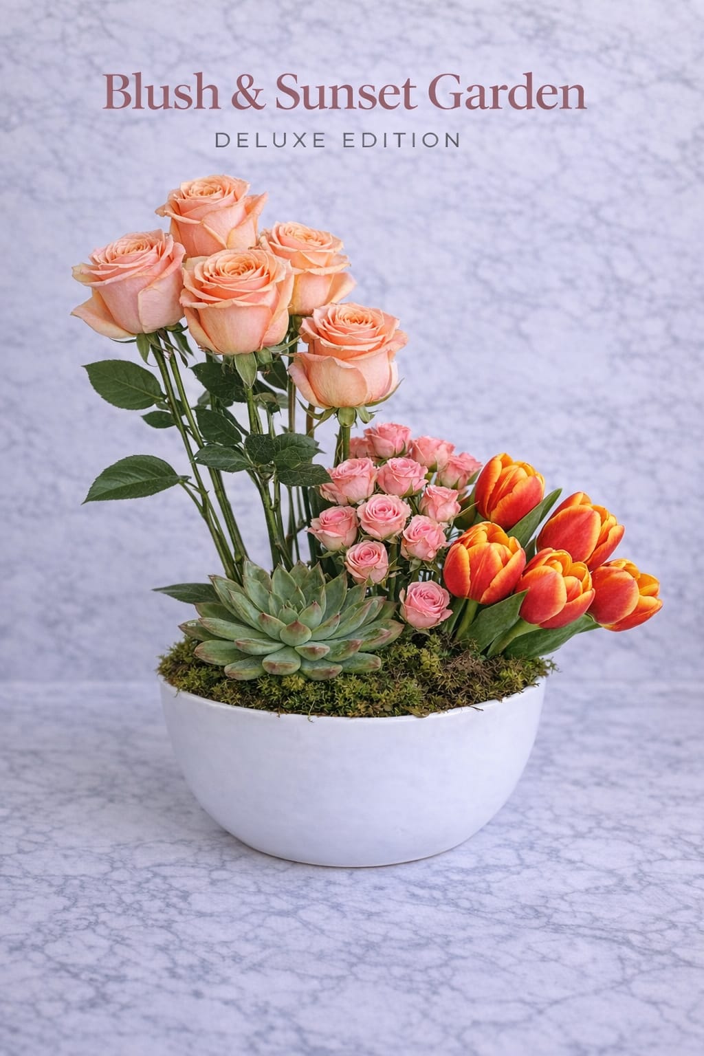 Althea delight - A bold yet refined floral composition that blends soft romance with vibrant seasonal energy. This design features elegant blush roses rising vertically, creating height and structure, while clusters of delicate spray roses add softness and continuity. On the opposite side, a vivid grouping of bi-color tulips in warm sunset tones introduces movement, contrast, and a modern seasonal touch. Their natural curvature brings life and direction to the arrangement, balancing the more structured rose elements. At the base, a sculptural succulent anchors the composition, surrounded by fresh moss that enhances the organic, garden-inspired aesthetic. The clean white ceramic bowl keeps the design minimal and contemporary, allowing the colors and textures to stand out.