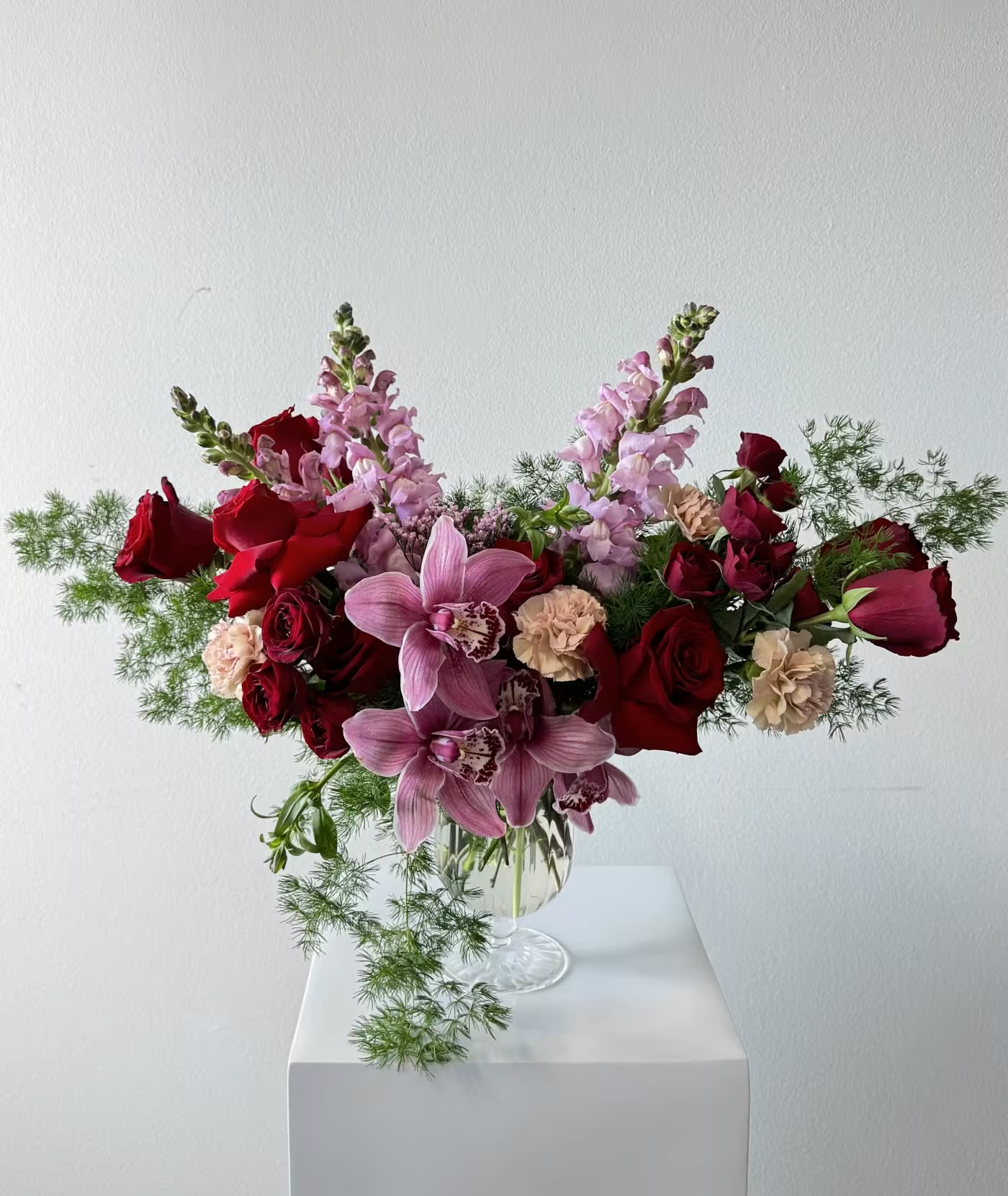 Elegant Bouquet - Imagine a bouquet that’s a total heart-stealer: red roses, dusty pink carnations, red spray roses, pink cymbidium orchids, and lavender snapdragons, all mingling in a burst of joy. This stunner’s a bestseller, crafted with love by your go-to Irvine florist, and it’s perfect for those classic souls who adore a little luxury.  First, the red roses—oh, they’re pure romance, singing of love and passion in every petal. Then come the dusty pink carnations, soft and sweet, wrapping you in gratitude and warmth. Red spray roses dance in like little bursts of happiness, full of admiration and cheer. The pink cymbidium orchids? They’re the elegant stars, glowing with grace and everlasting devotion. And those lavender snapdragons add a whimsical twist, standing tall with charm and magic.  This bouquet’s a love story in bloom—perfect for showing your soulmate just how much they mean to you! Red roses bring timeless passion, dusty pink carnations offer a tender thank-you, and red spray roses sprinkle in fun. Pink cymbidium orchids shine with sophistication, while lavender snapdragons weave in enchantment